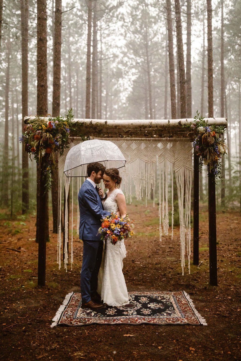 Wedding photos in the pine tree grove on a rainy wedding day at Burlap and Bells. 