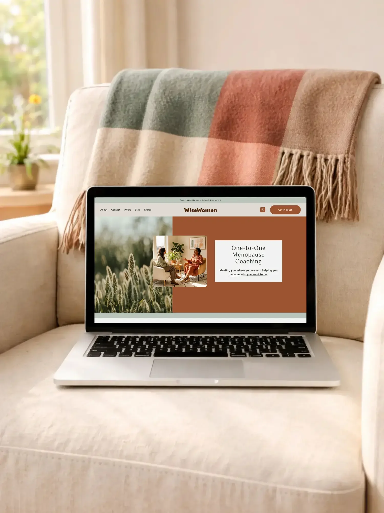 Open MacBook representing the 3-day Squarespace website build service, resting on a cream armchair with a blanket over it.