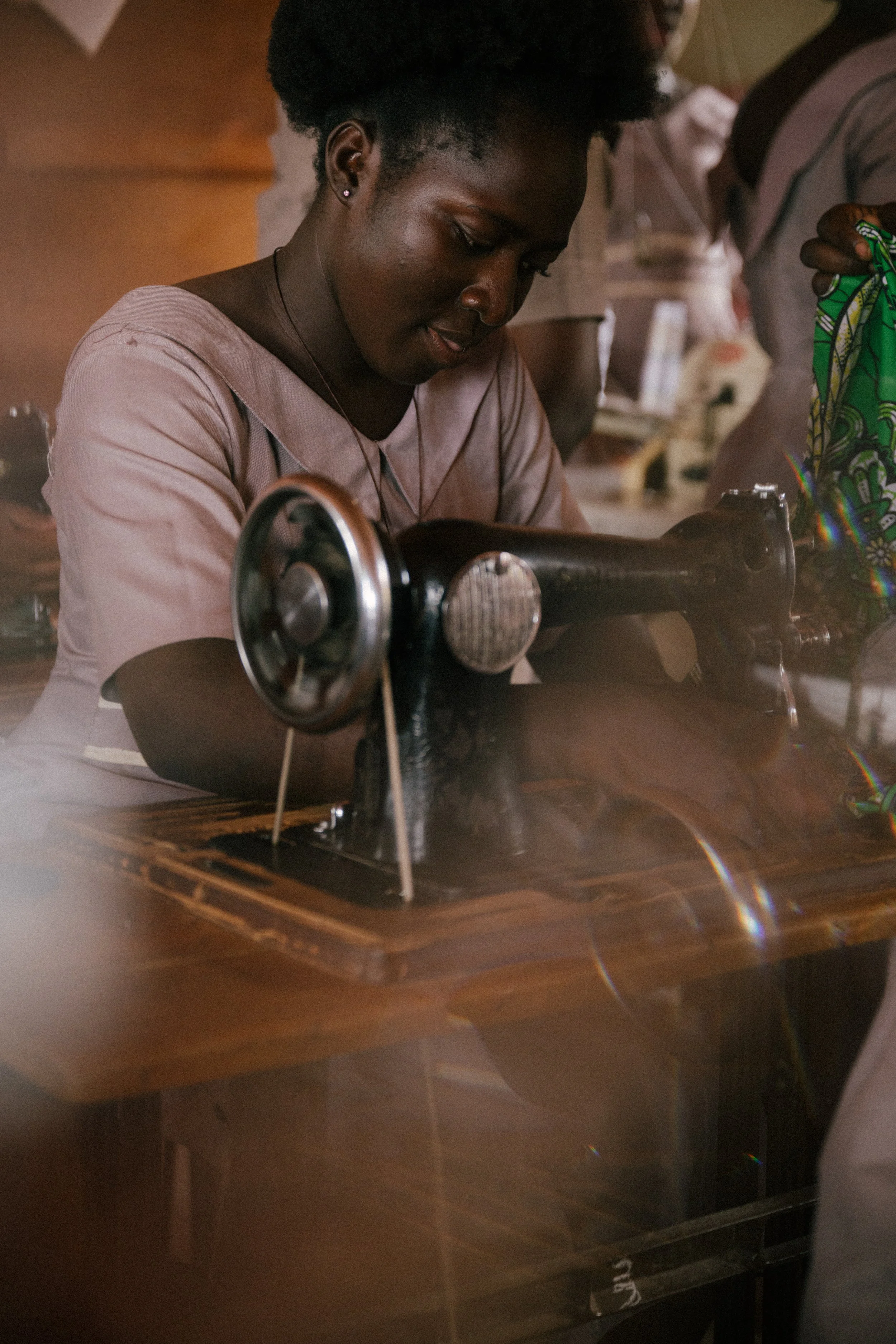 A woman sewing on a vintage black sewing machine.