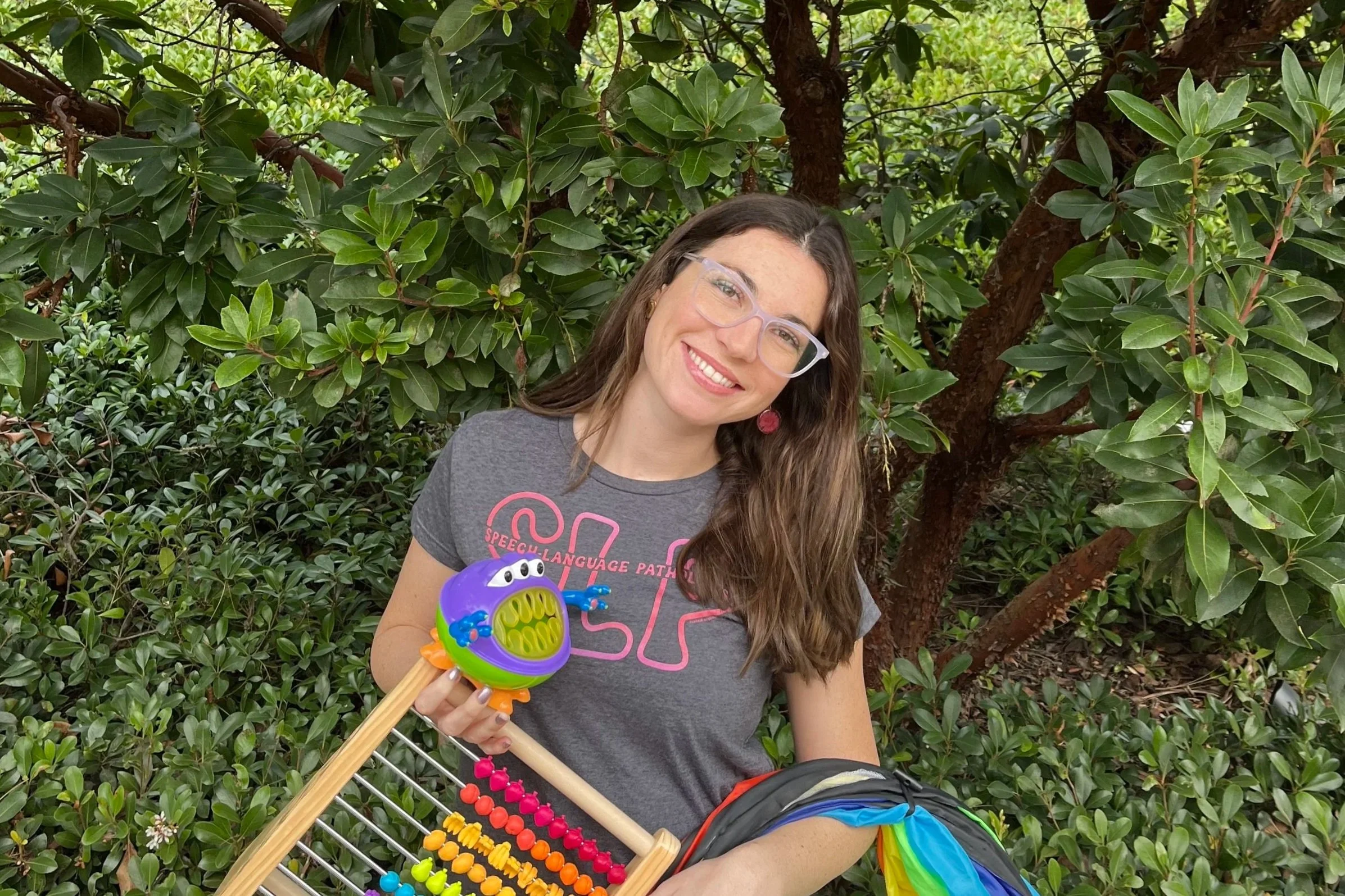 Speech-language pathologist Alyssa Pitts smiling with toys used for speech therapy