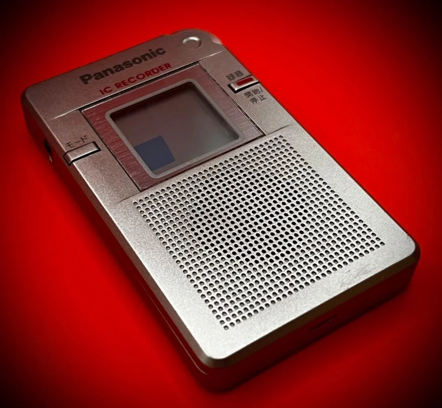 Panasonic RR-DR60 digital voice recorder left perspective view - red background