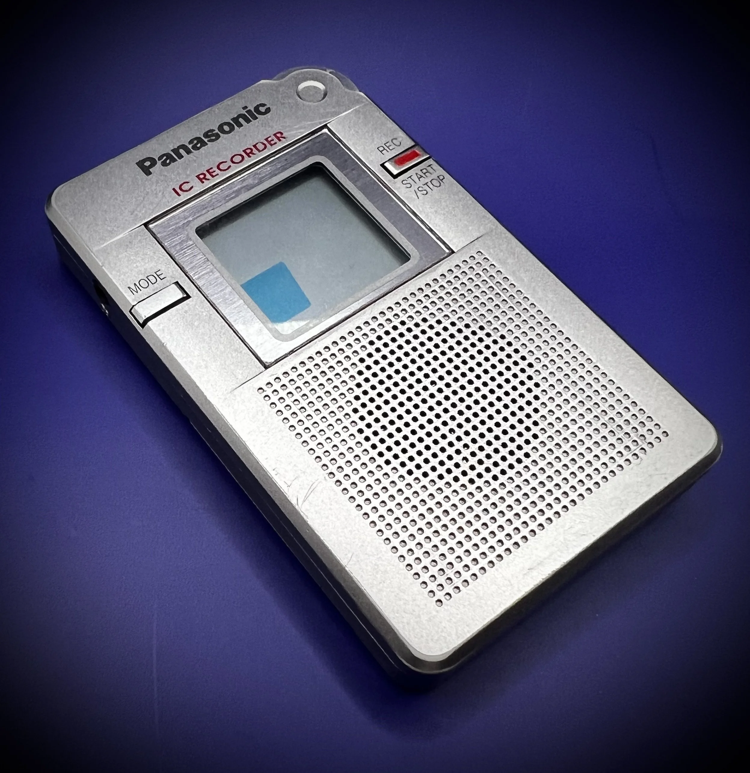Panasonic RR-DR60 digital voice recorder left perspective view - blue background