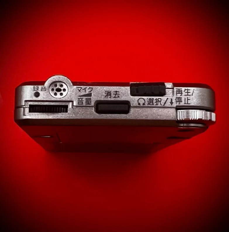 Panasonic RR-DR60 digital voice recorder top view - red background