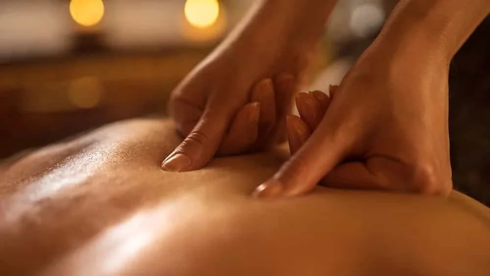 Two thumbs applying pressure to back for massage