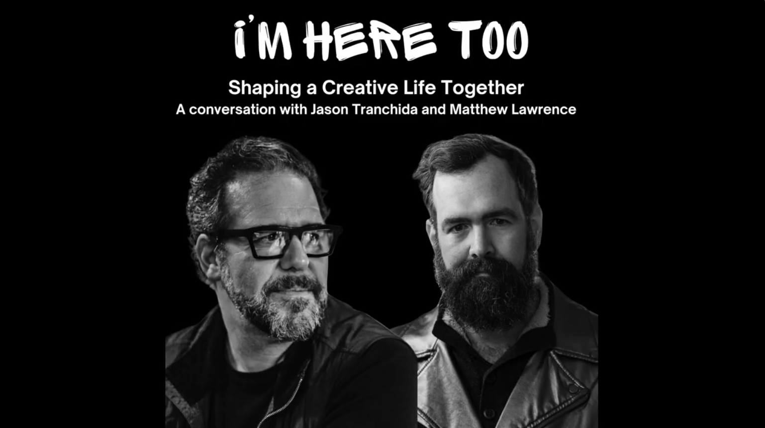 Two men who have not yet gone gray against a solid black background.