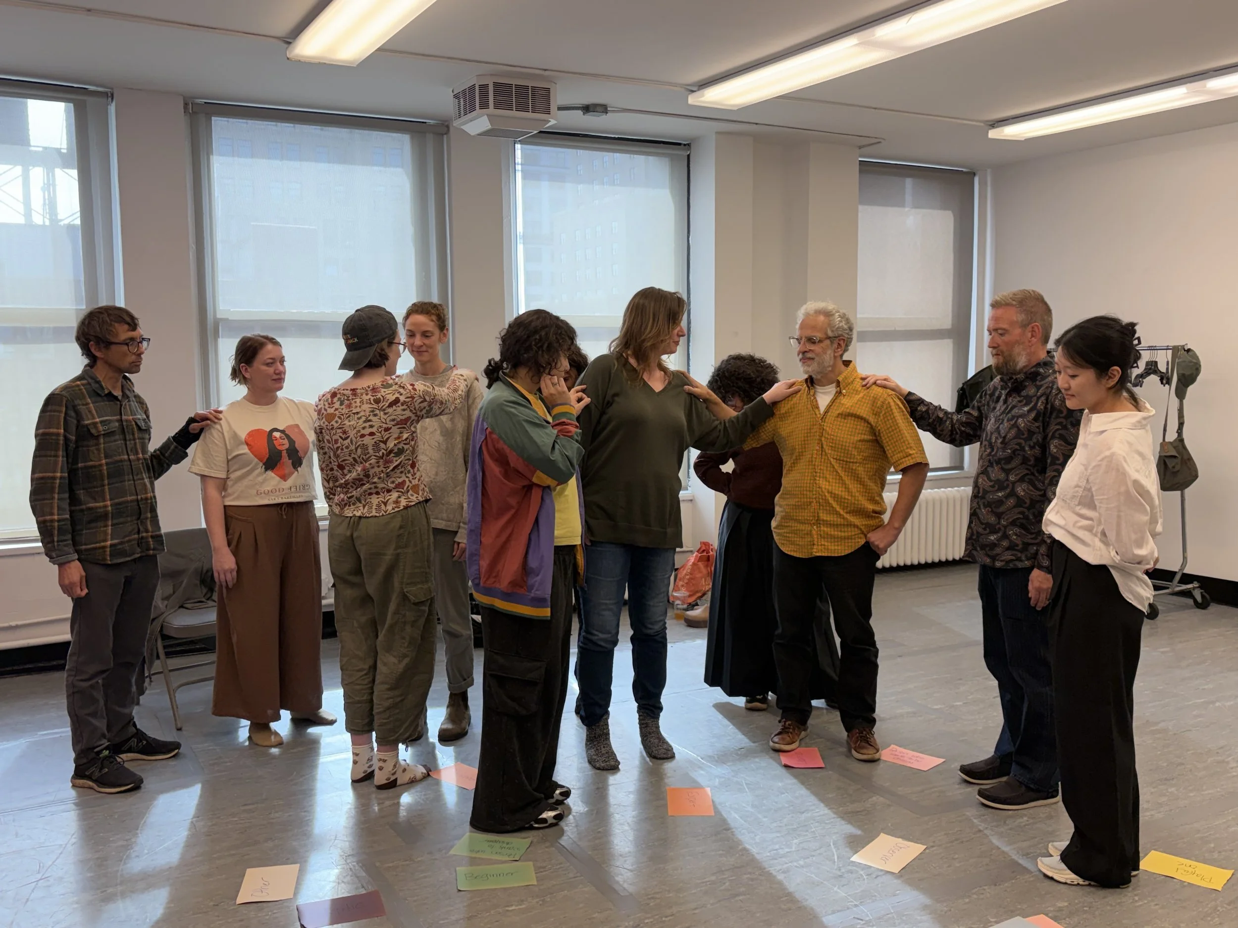 Group of people with hands on each other's shoulders during a group therapy training