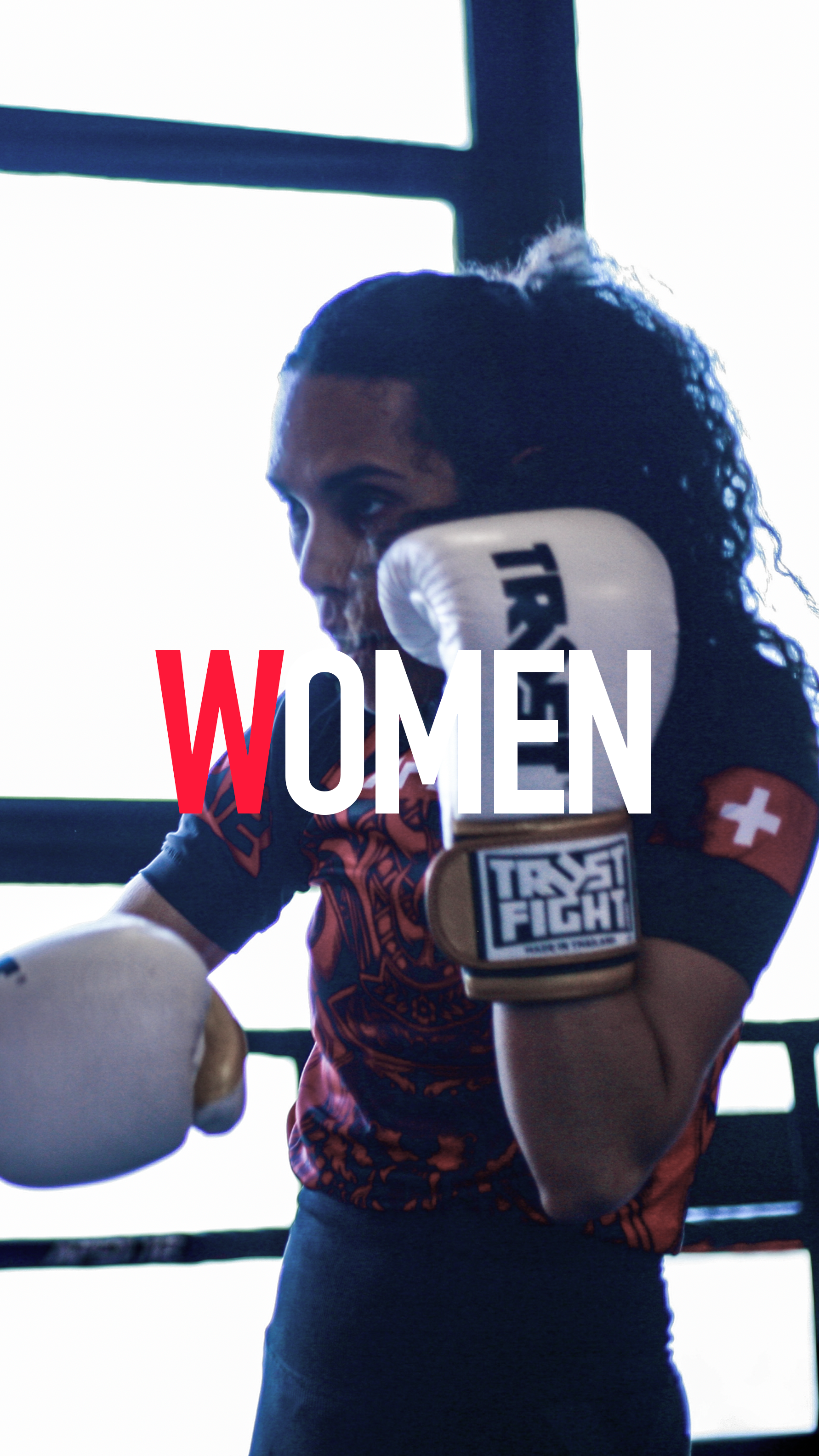 Une femme en train de s'entraîner à la boxe dans une salle, portant des gants de boxe et un t-shirt avec un motif, avec le mot 'WOMEN' en superposition.