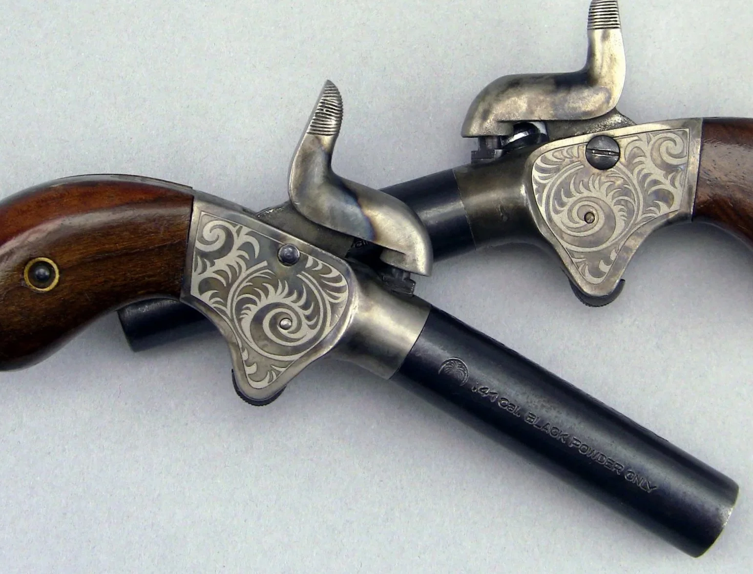 Pocket Pistols with decorative scrollwork laser engraving.