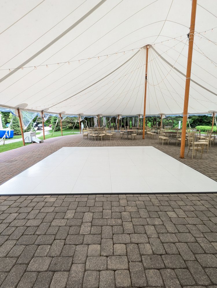 All-white dance floor on a patio under a tent