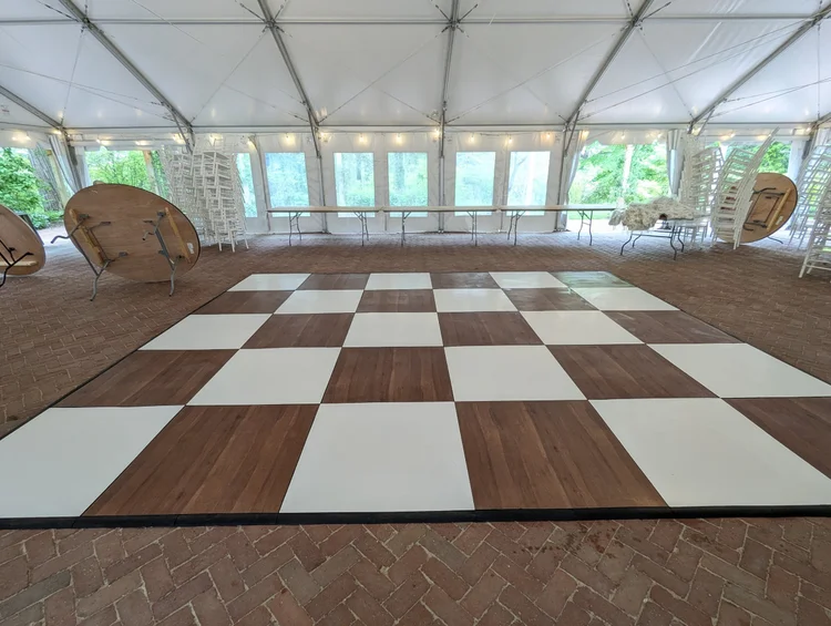 Dark maple and white checkered dance floor under a tent