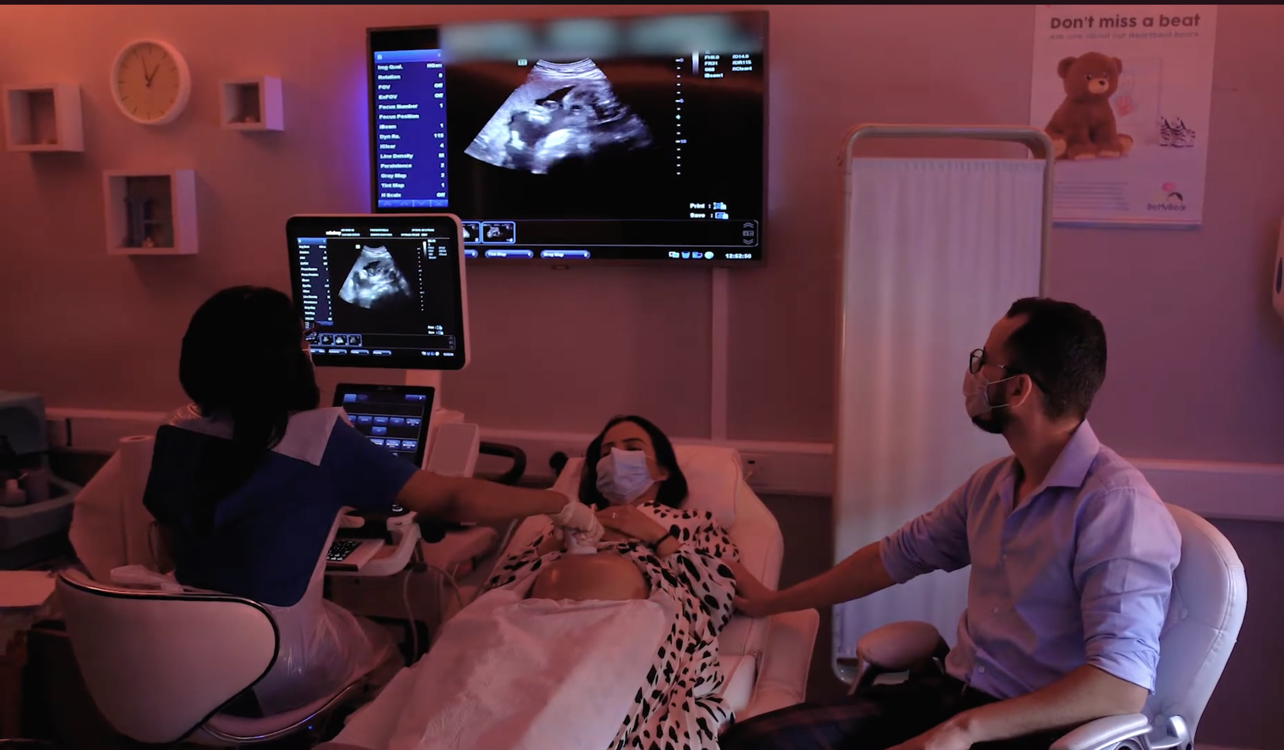 Pregnant couple watching baby heartbeat scan during prenatal ultrasound appointment at Imaginatal clinic