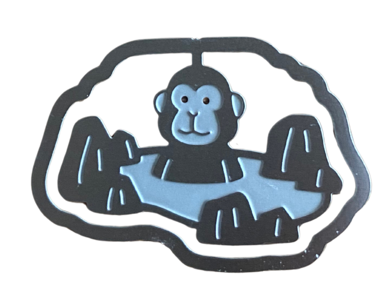 Silver paperclip in the shape of a smiling monkey in an onsen