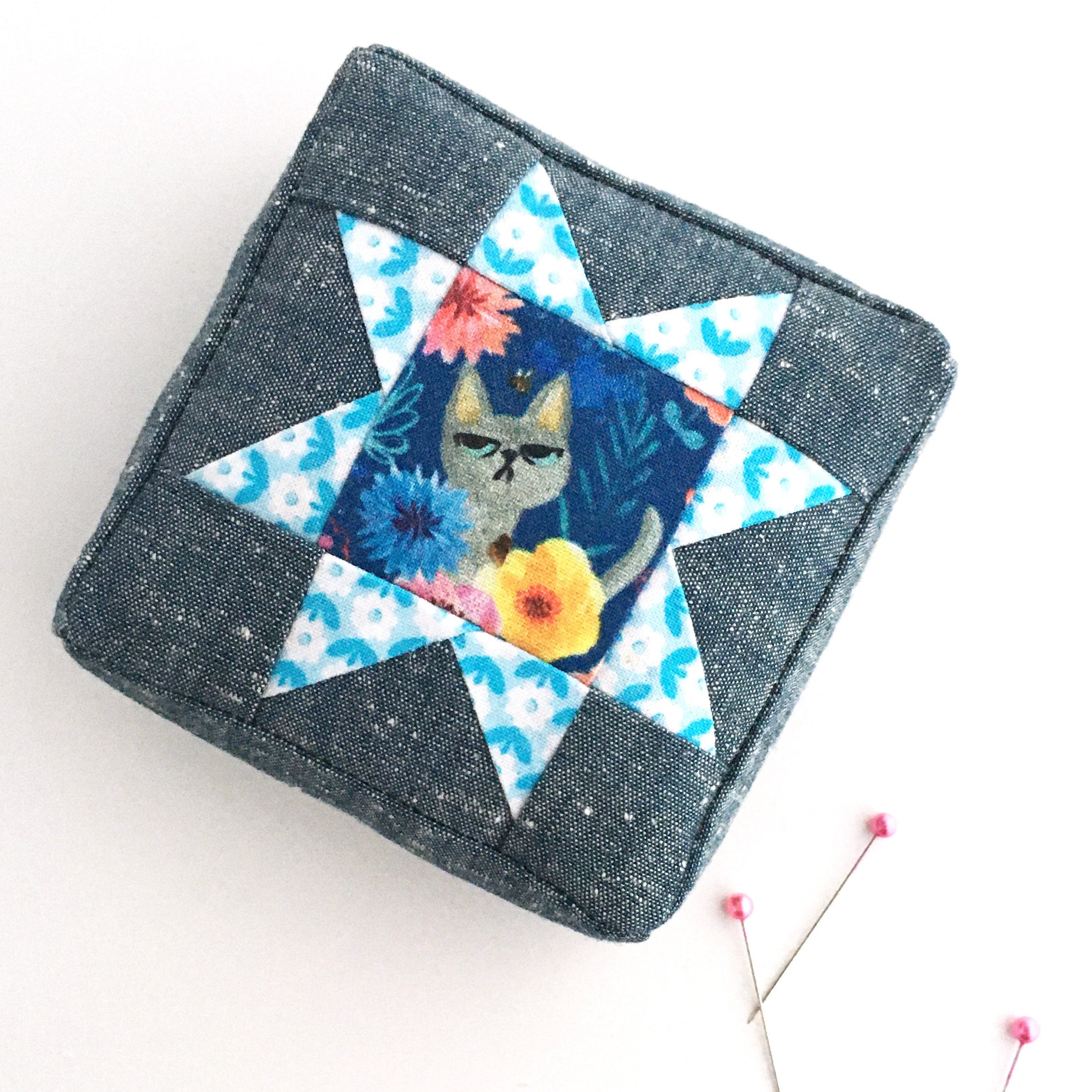 Chambray and quilting cotton square pincushion with a star block top.