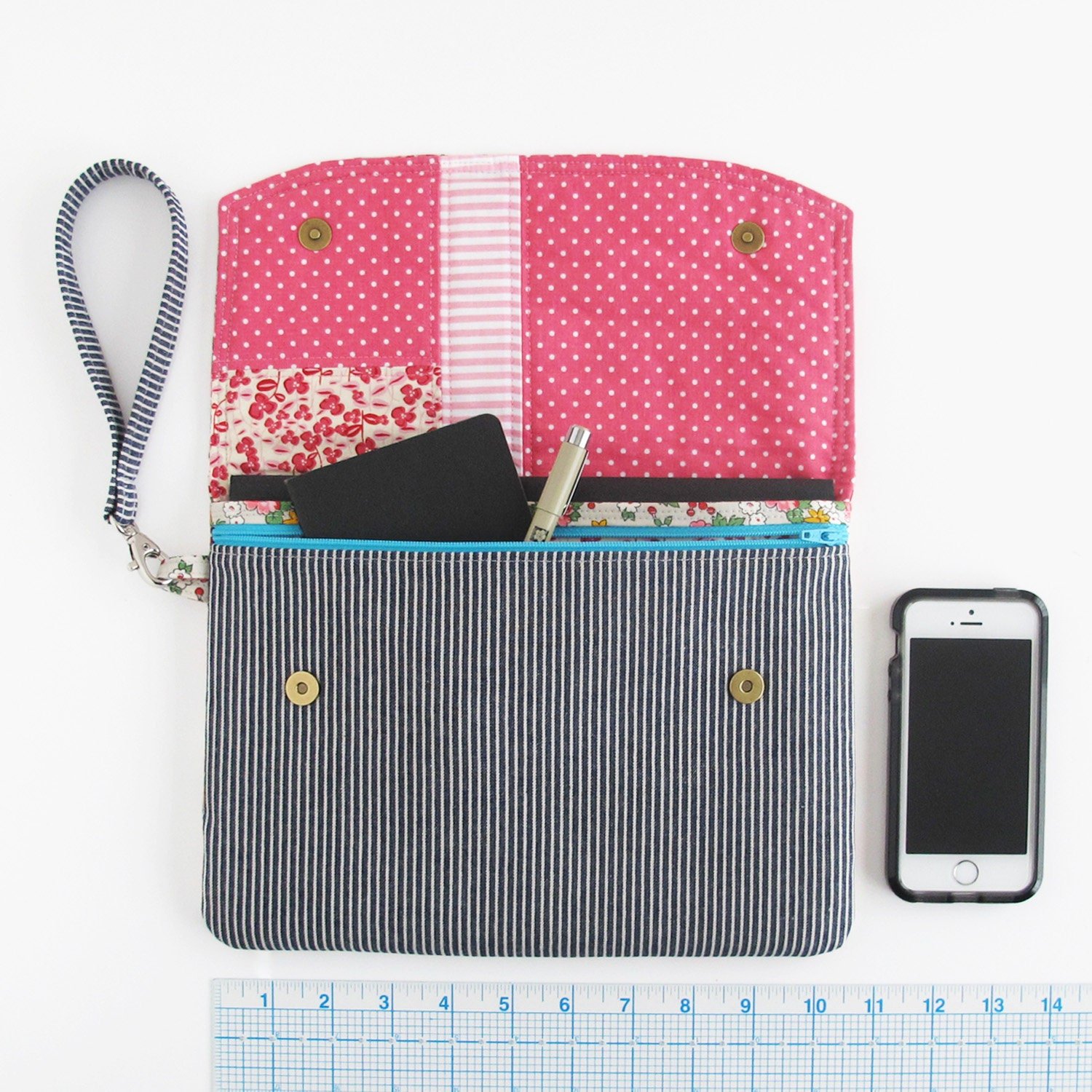 The larger size in the sewing with a phone, journal, and pen for size reference.