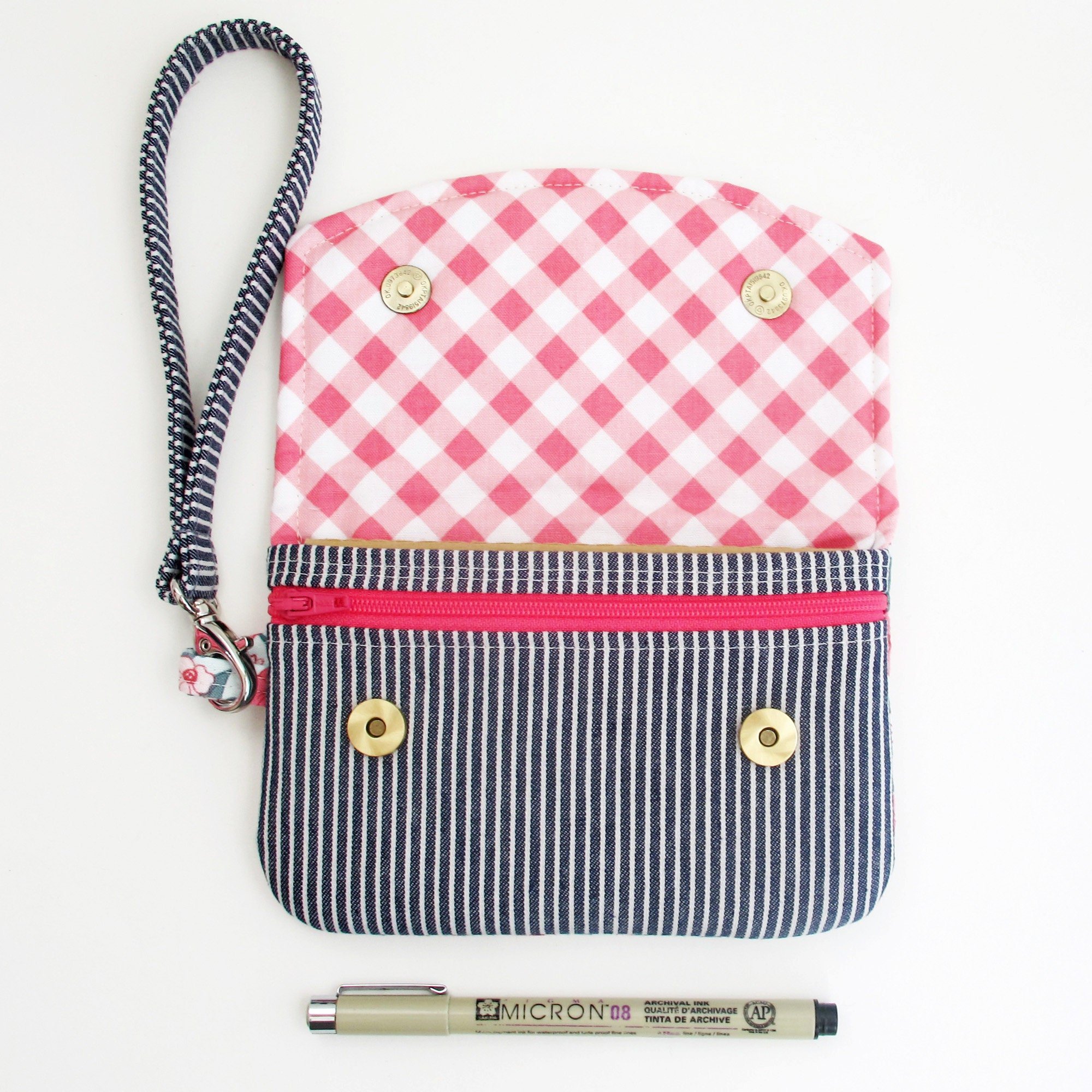 Zip Pocket Pouch Wristlet open to show the interior of the flap and the magnetic snap closures.