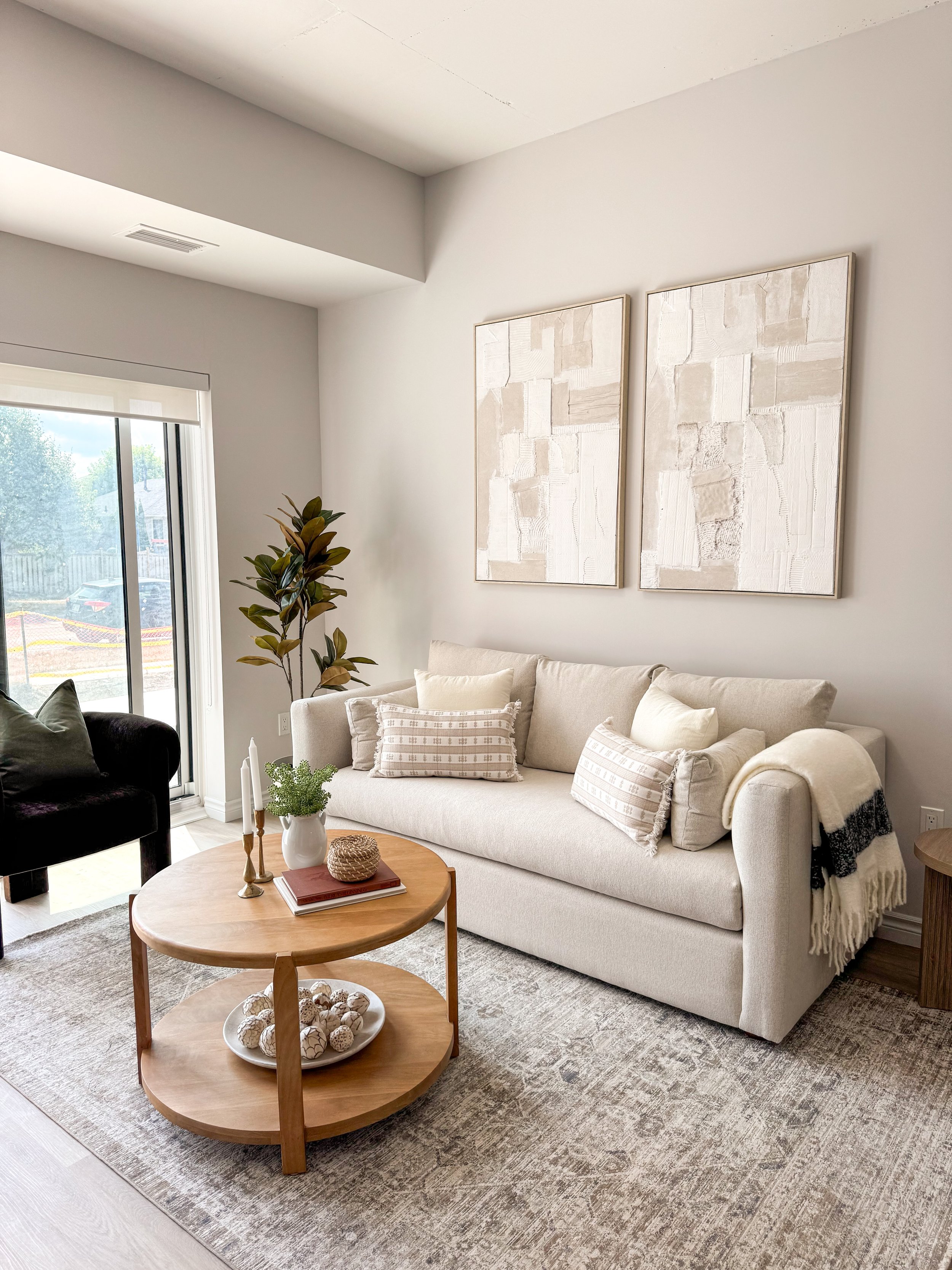 Modern staged kitchen in a new built complex with stainless steel refrigerator, oven, microwave, white countertop, black sink faucet, and wooden cabinets