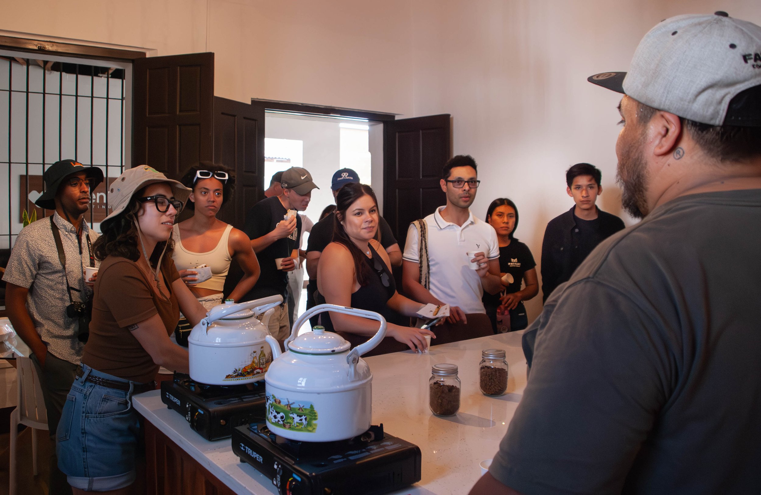 Group of students learning how to brew coffee from Guatemalan baristas