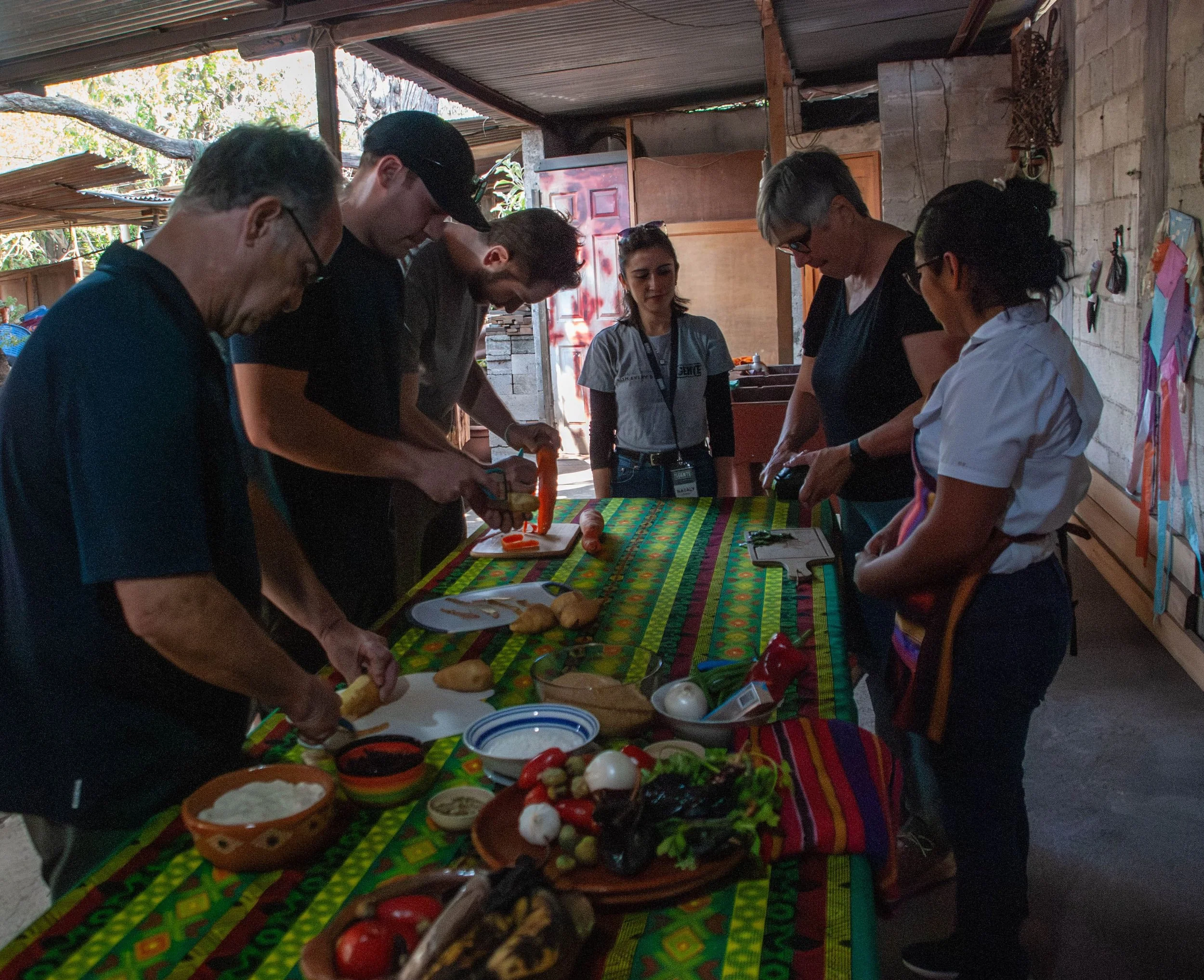Un grupo de turistas cortando verduras durante una clase de cocina
