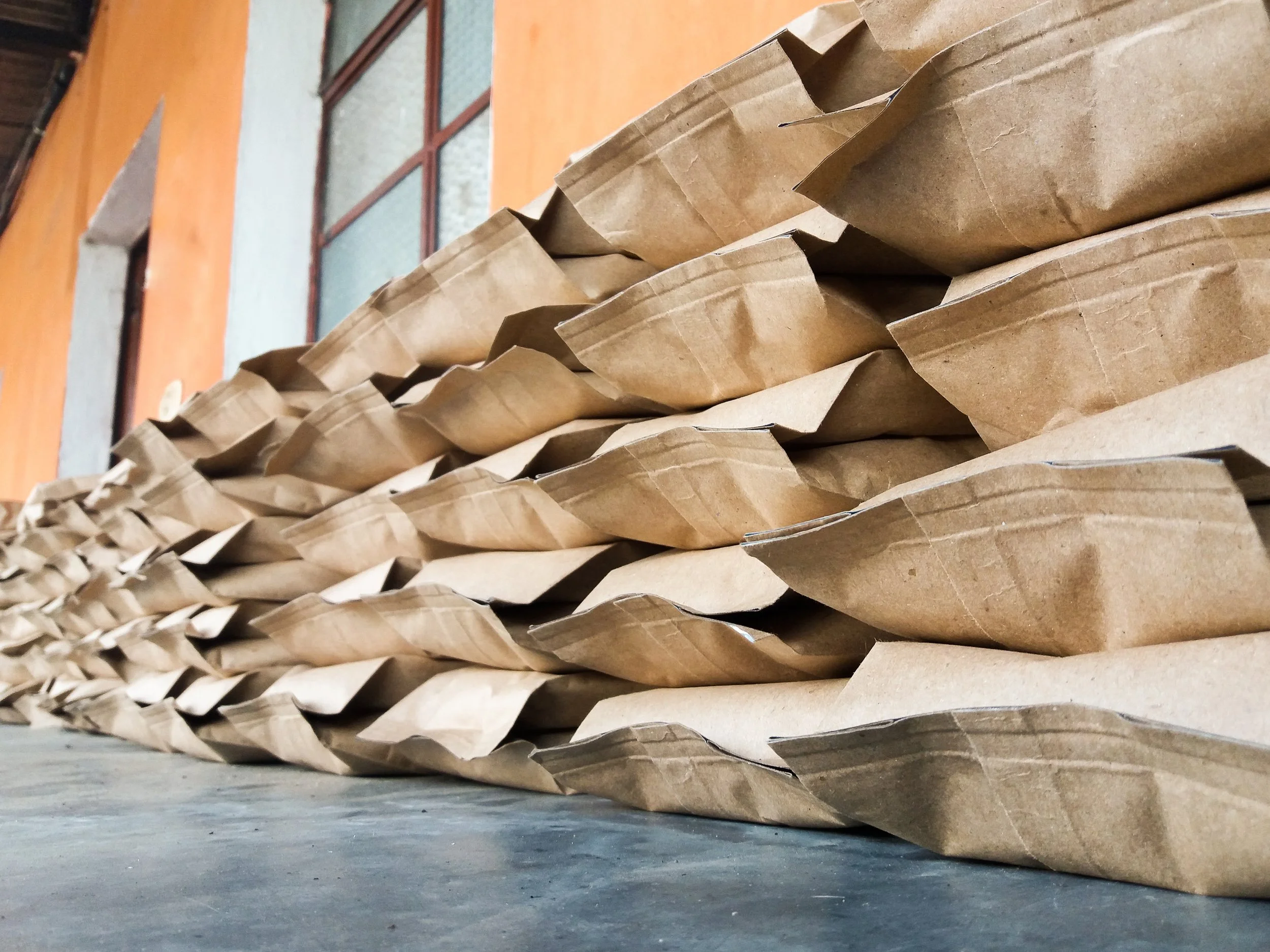 De La Gente 12 oz bags stacked on a table ready for a bulk sale | De La Gente roasted coffee beans