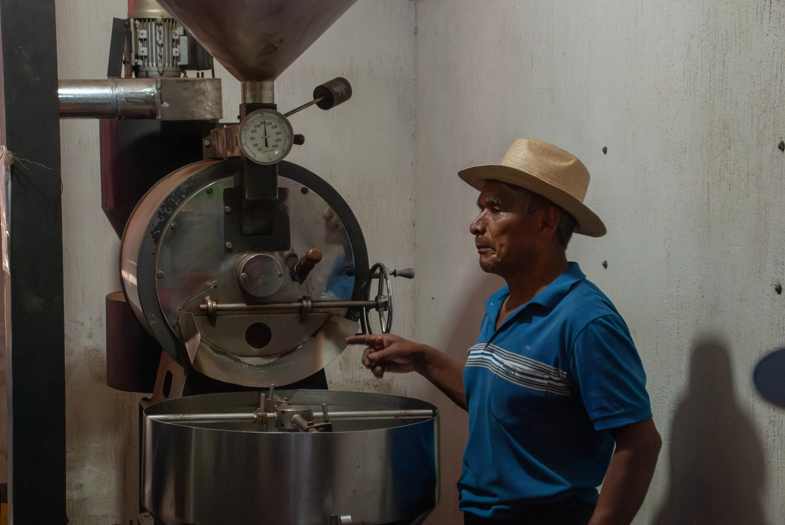 Coffee producer next to an industrial coffee roaster owned by Shigualos Coffee Cooperative in the Antigua region