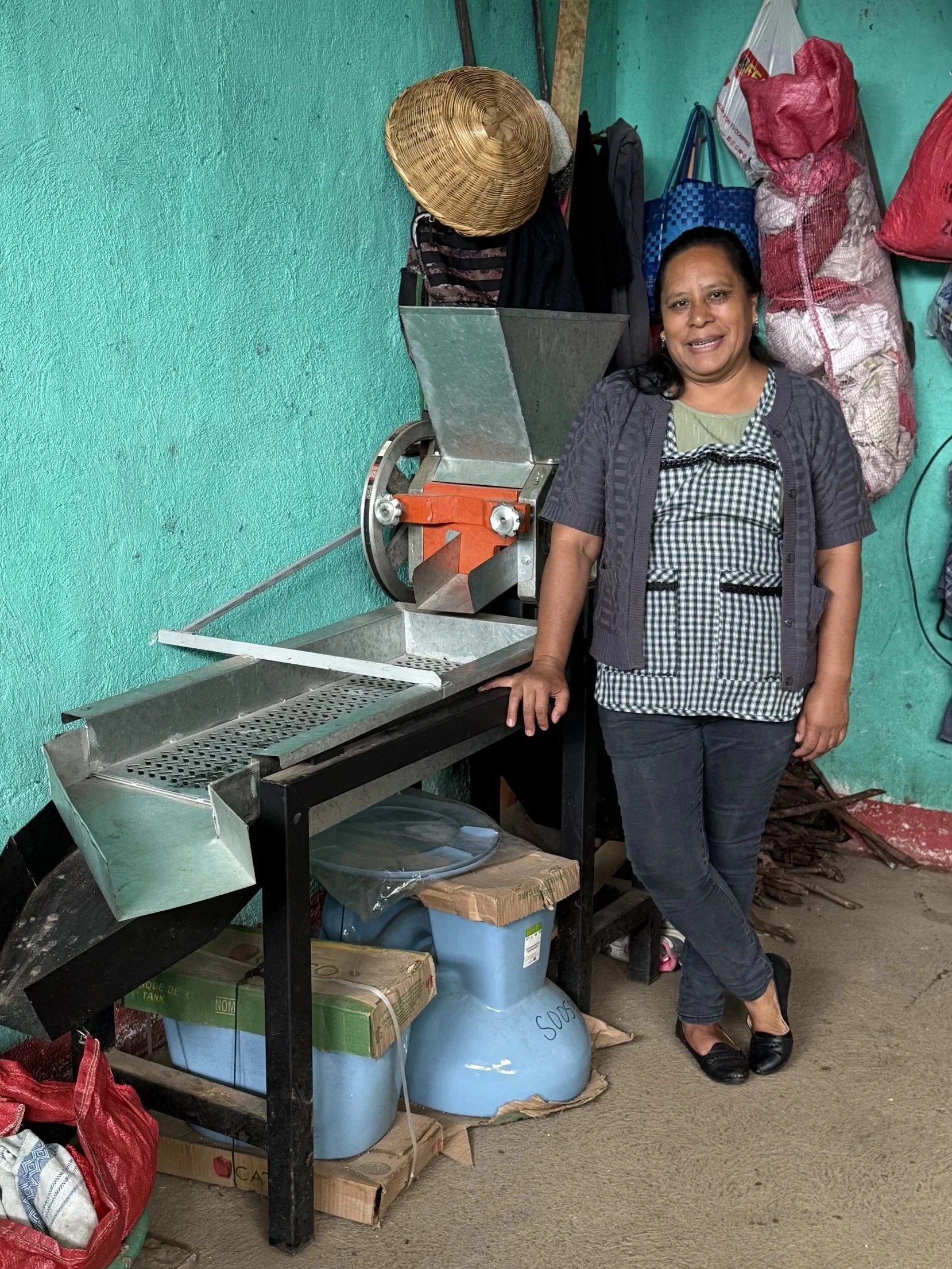 creating change for women coffee producers | woman coffee producer with donated de-pulper machine