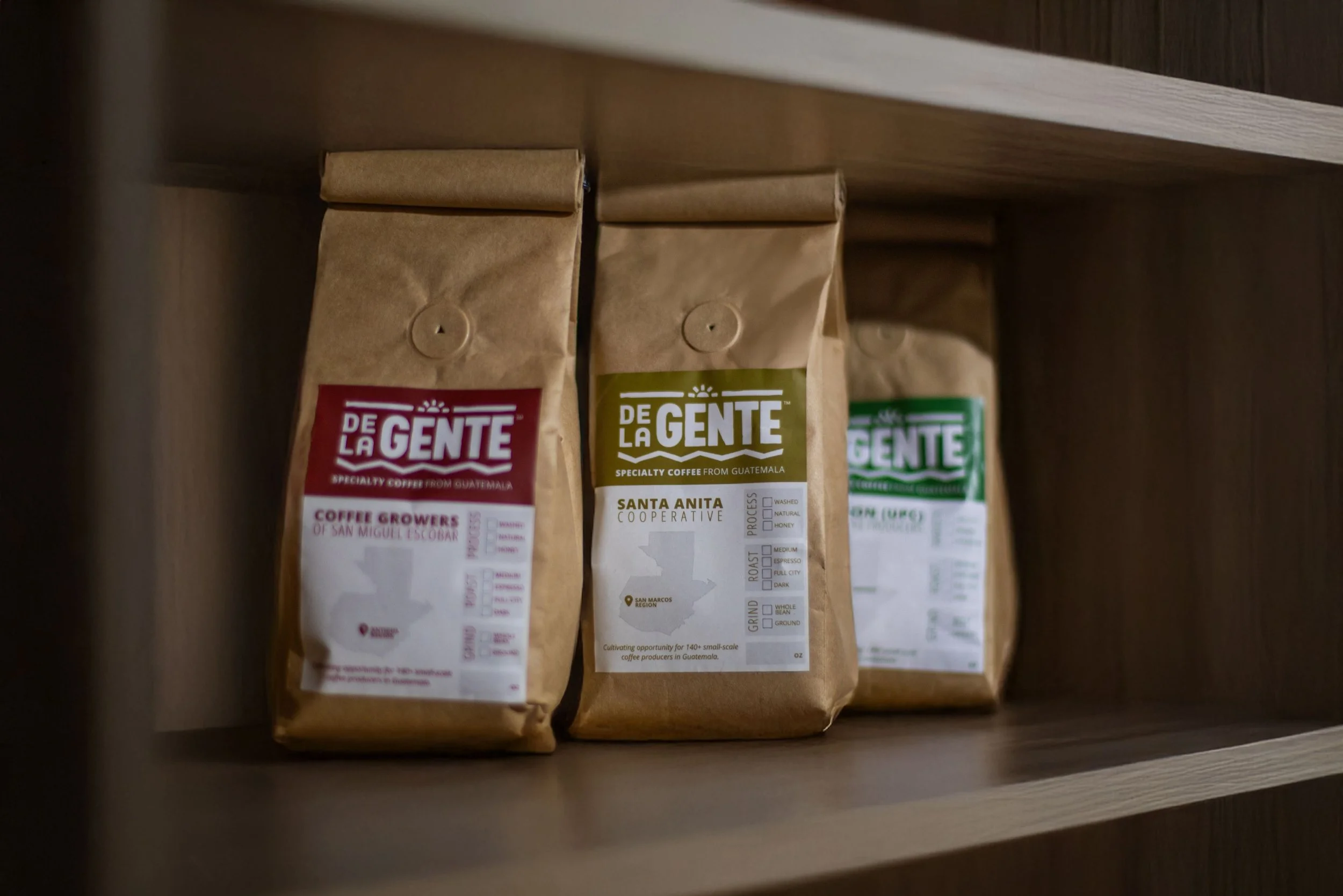 De La Gente coffee bags on shelf for a coffee fundraiser | roasted coffee beans