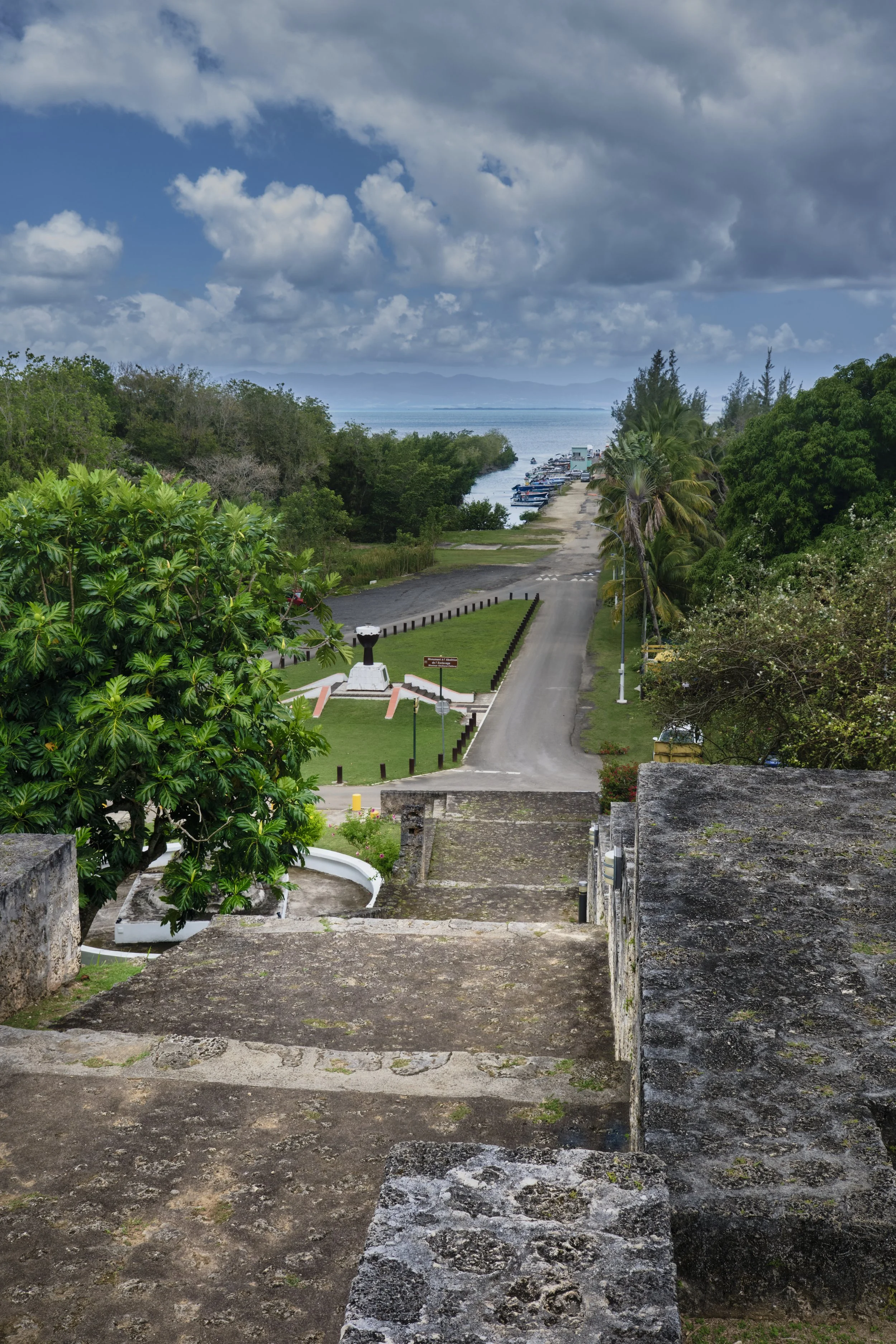 The stairs up to the church yard, looking back to where the ship would have docked.  Climbing these after crossing the ocean, ill, weak.  And about to become the property of French colonists, making money from their labor. 