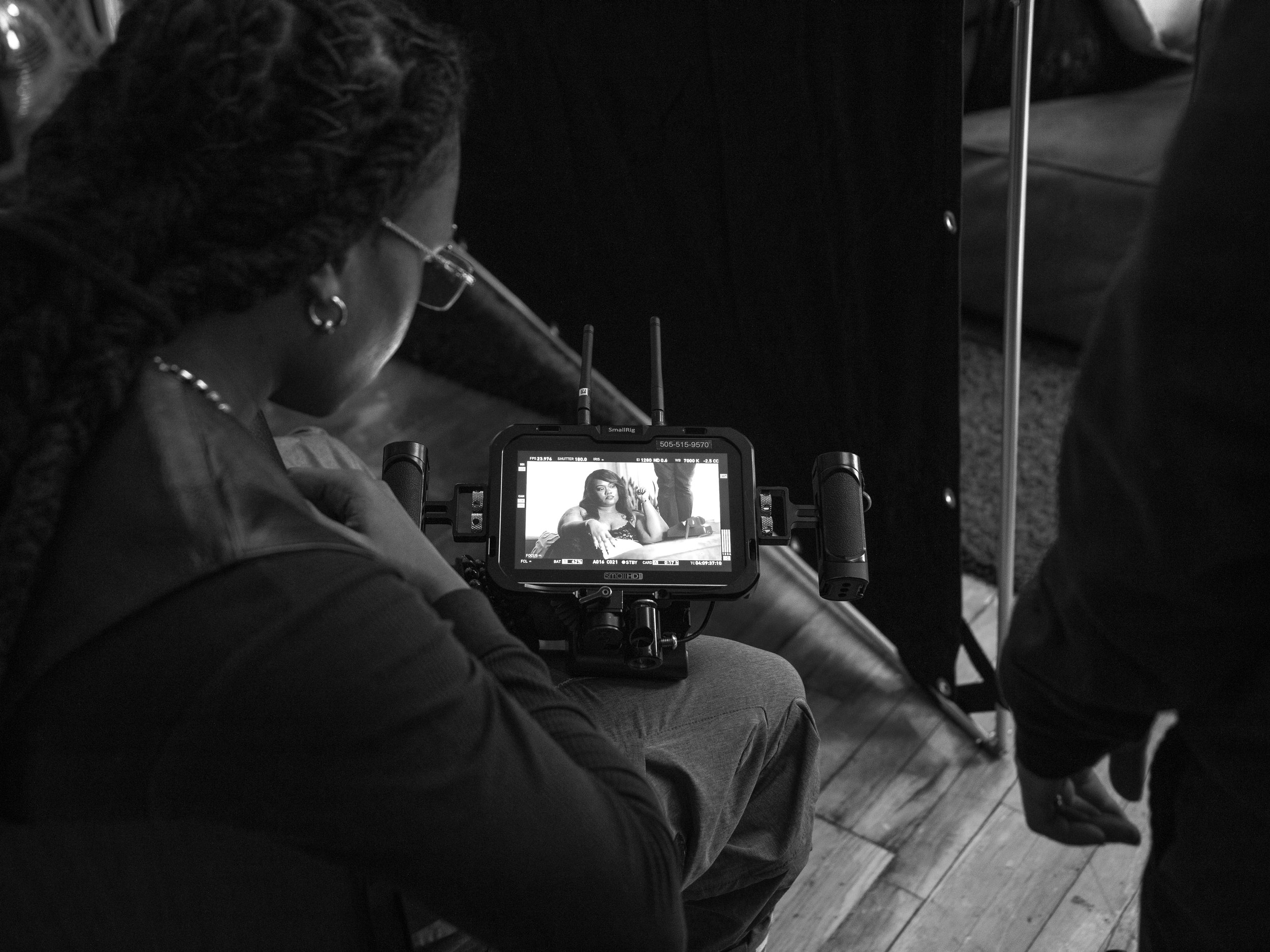 An African American DP and crew member focus on capturing a shot during a music video production.