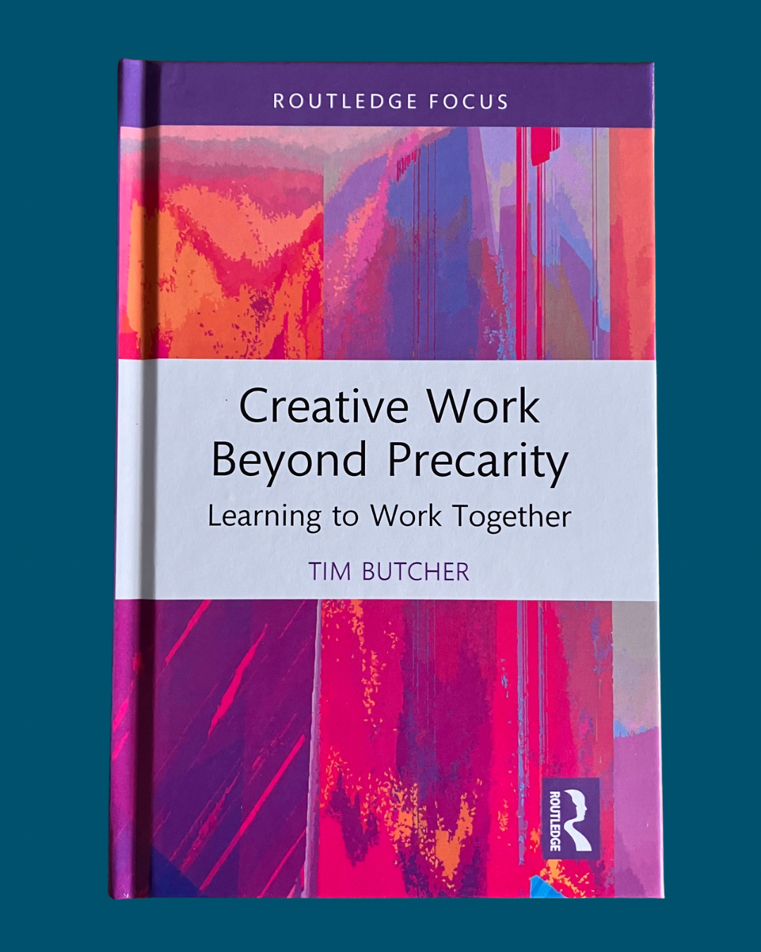 Book titled 'Creative Work Beyond Precarity: Learning to Work Together' by Tim Butcher, published by Routledge, with a colorful abstract cover featuring pink, purple, and orange hues.