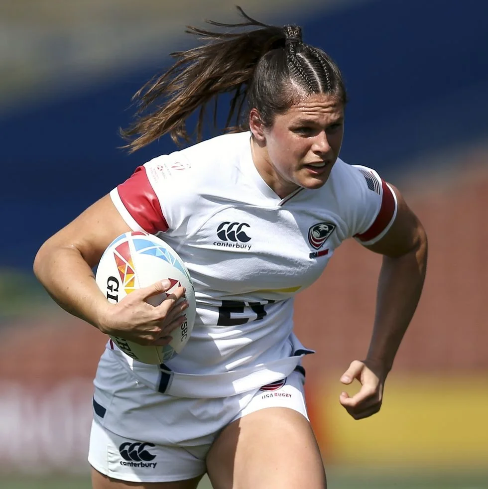 Ilona Maher charges down the pitch carrying a rugby ball