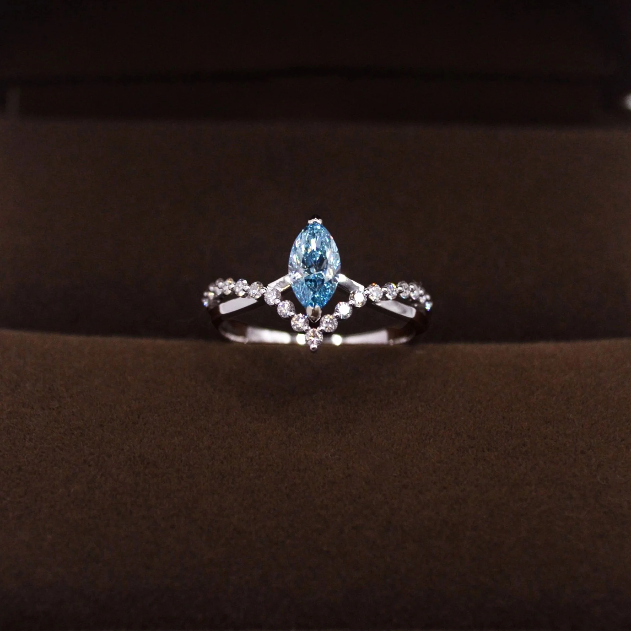 An elegant custom platinum infinity ring with a blue diamond resembling the serene sea.