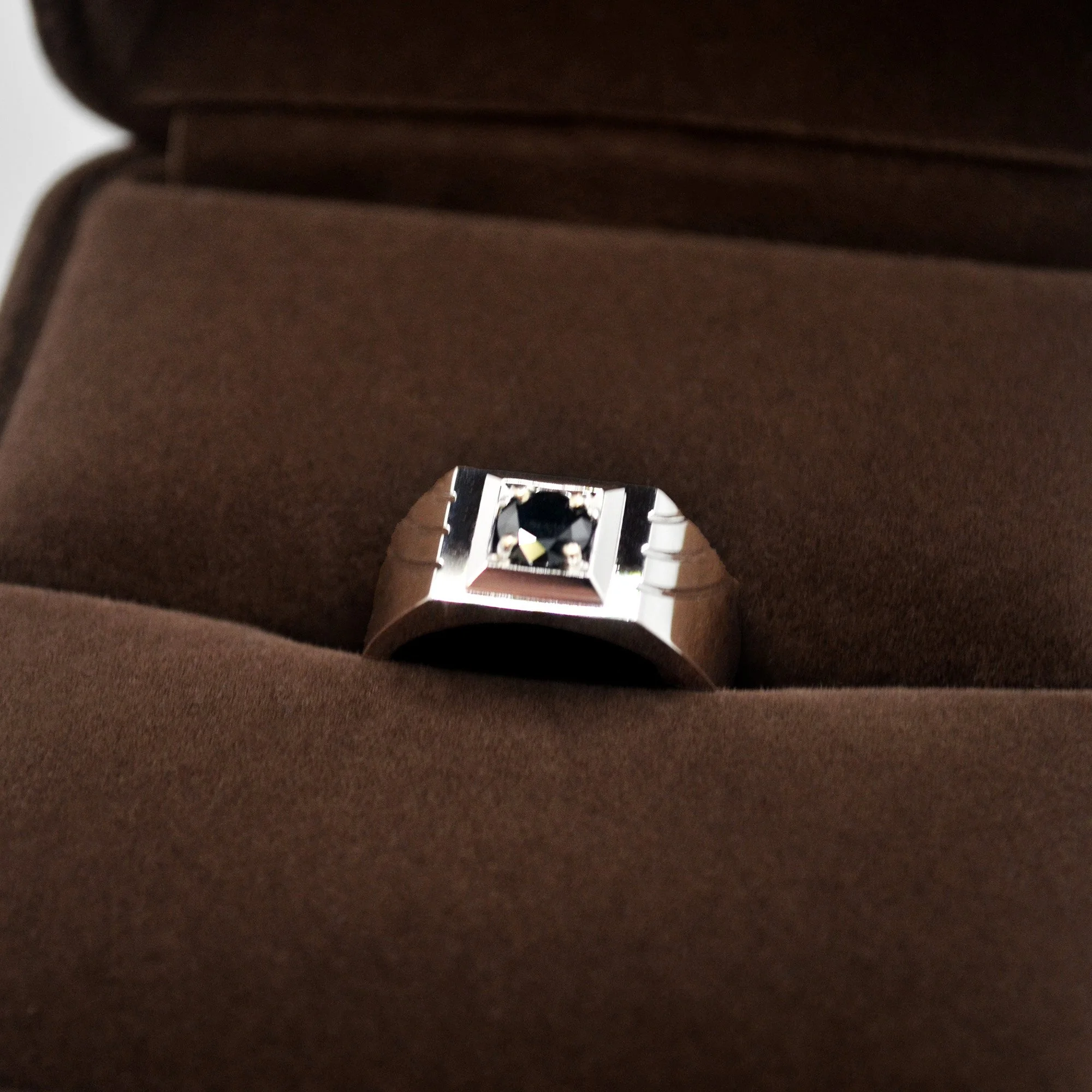 A striking memorial ring with a central black diamond set on a sleek, polished band, embodying everlasting memories.