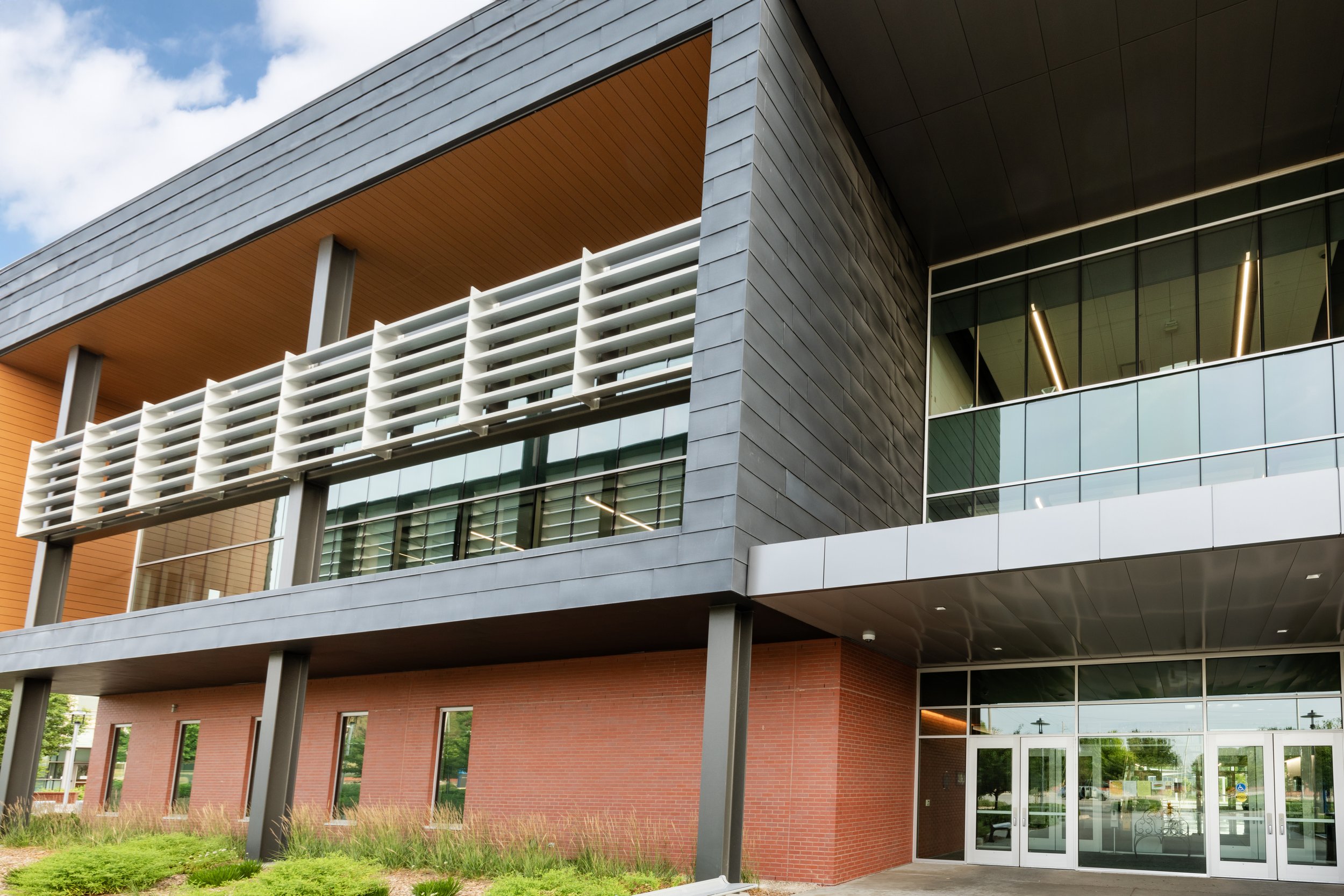 Modern architectural building with glass windows and metal cladding.