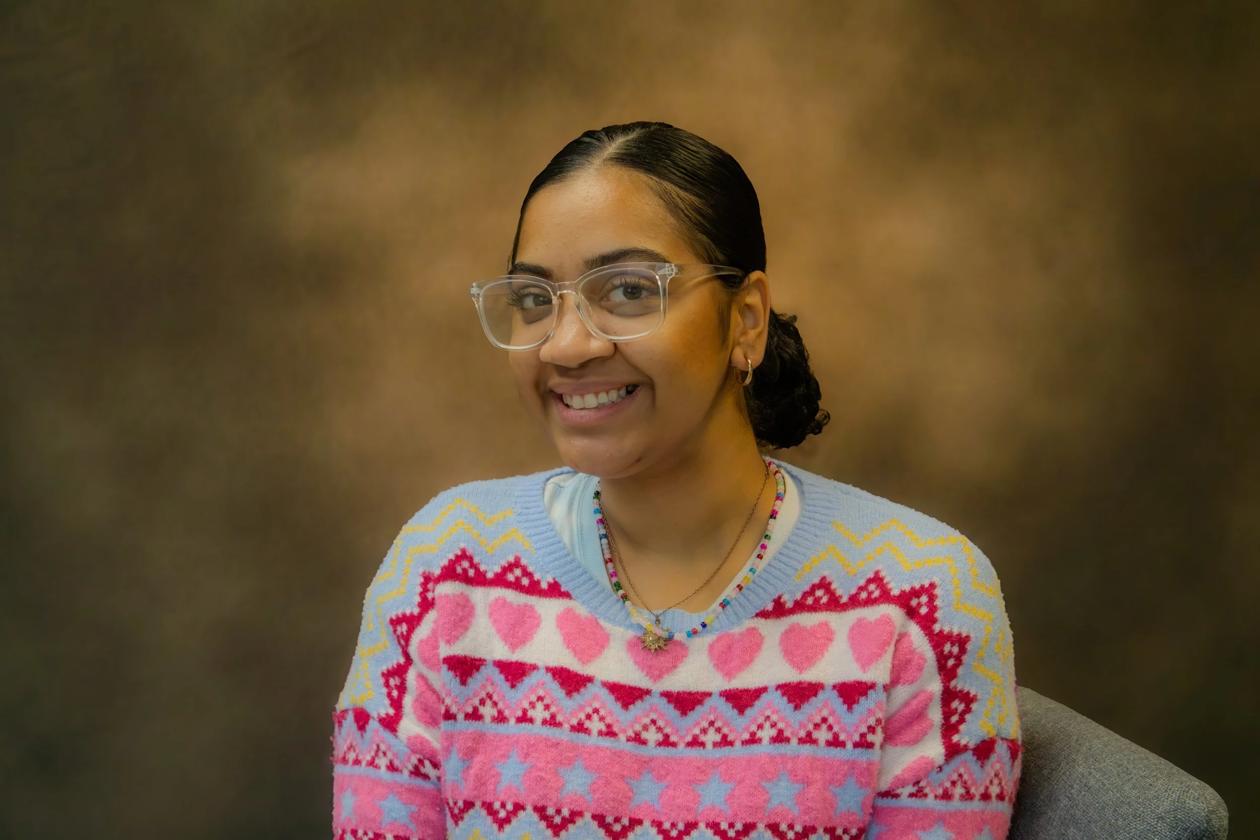 Minimalist icon of a person with a circular head and shoulders outlined in black on a light gray background.