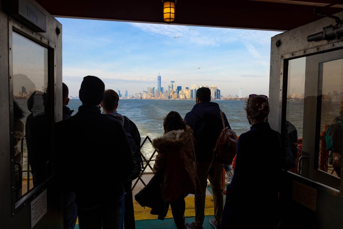Passengers look at the NYC skyline.