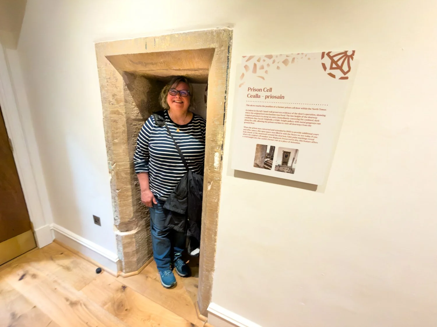 Debbie stands by the walled of entrance to the jail.