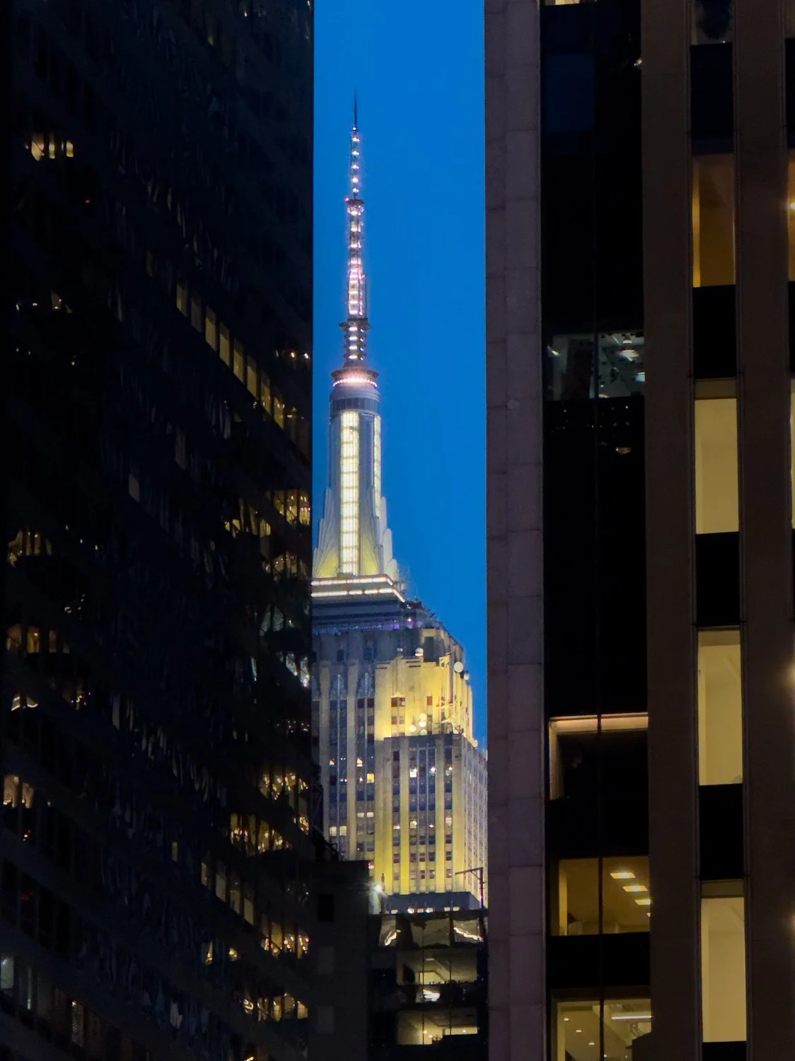 The Empire State Building peeks out from between skyscrapers.
