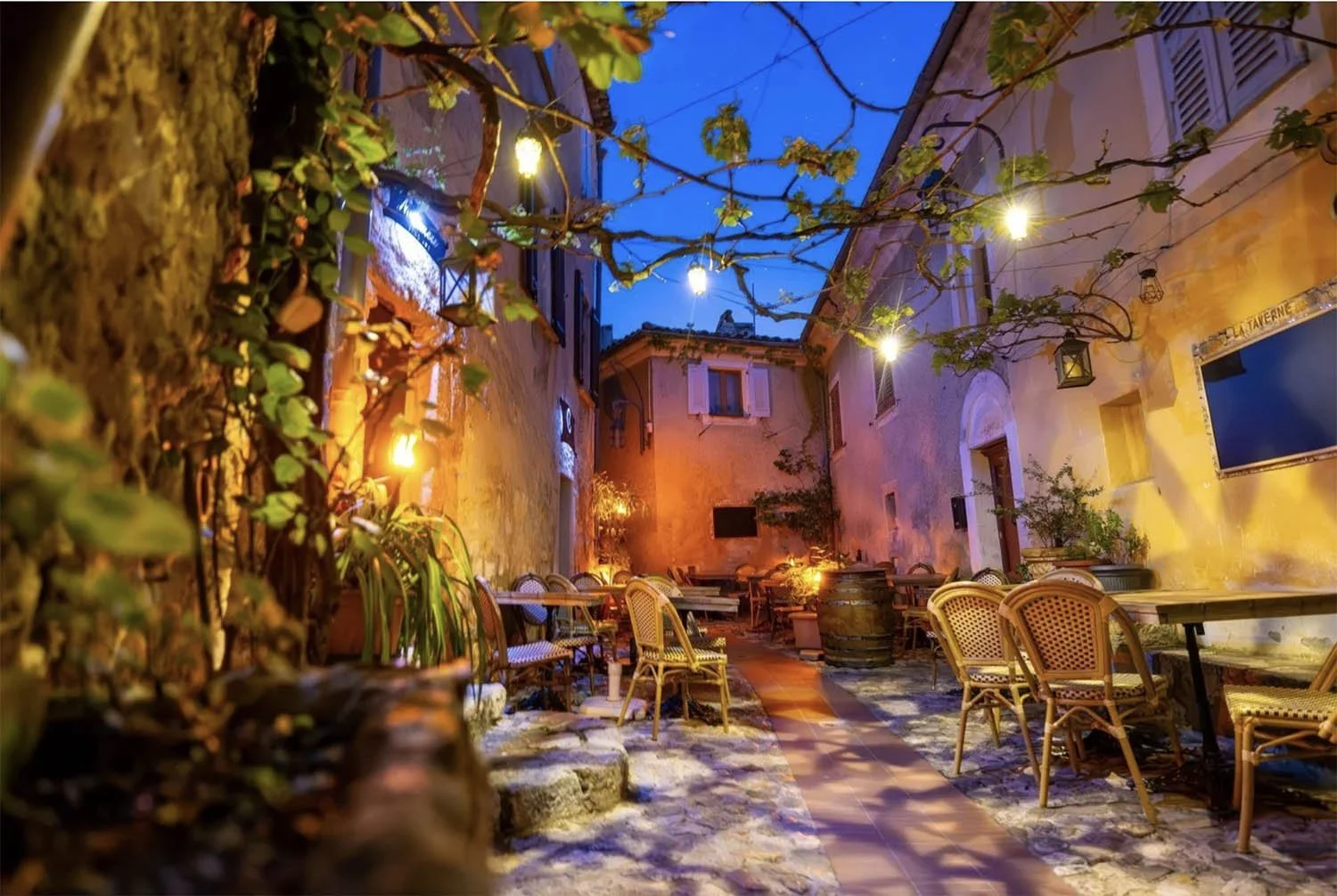 Night scene in Eze, France, with warm cafe light, reminiscent of Van Gogh's Cafe Terrace at Night.
