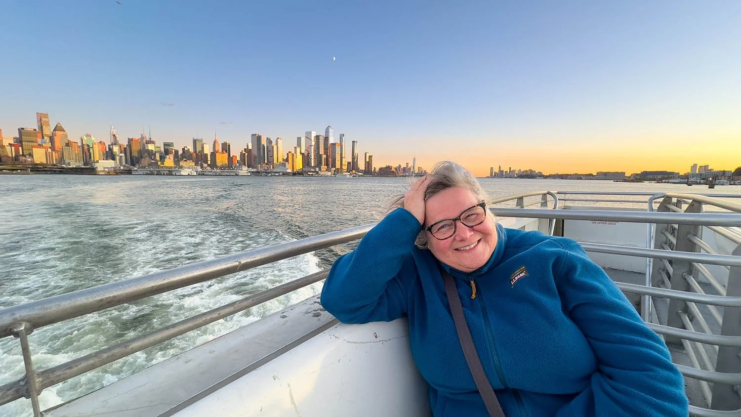 Debbie on a ferry with the NYC skyline.