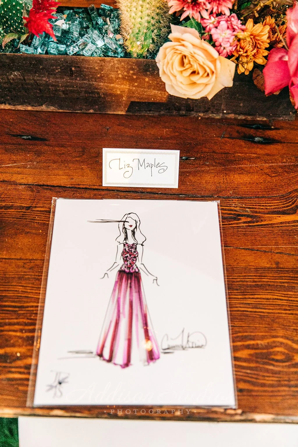Ink and marker fashion illustration of a wedding guest in a burgundy dress by Carmen Mosnia Hodge. Photo by Addison Studio 