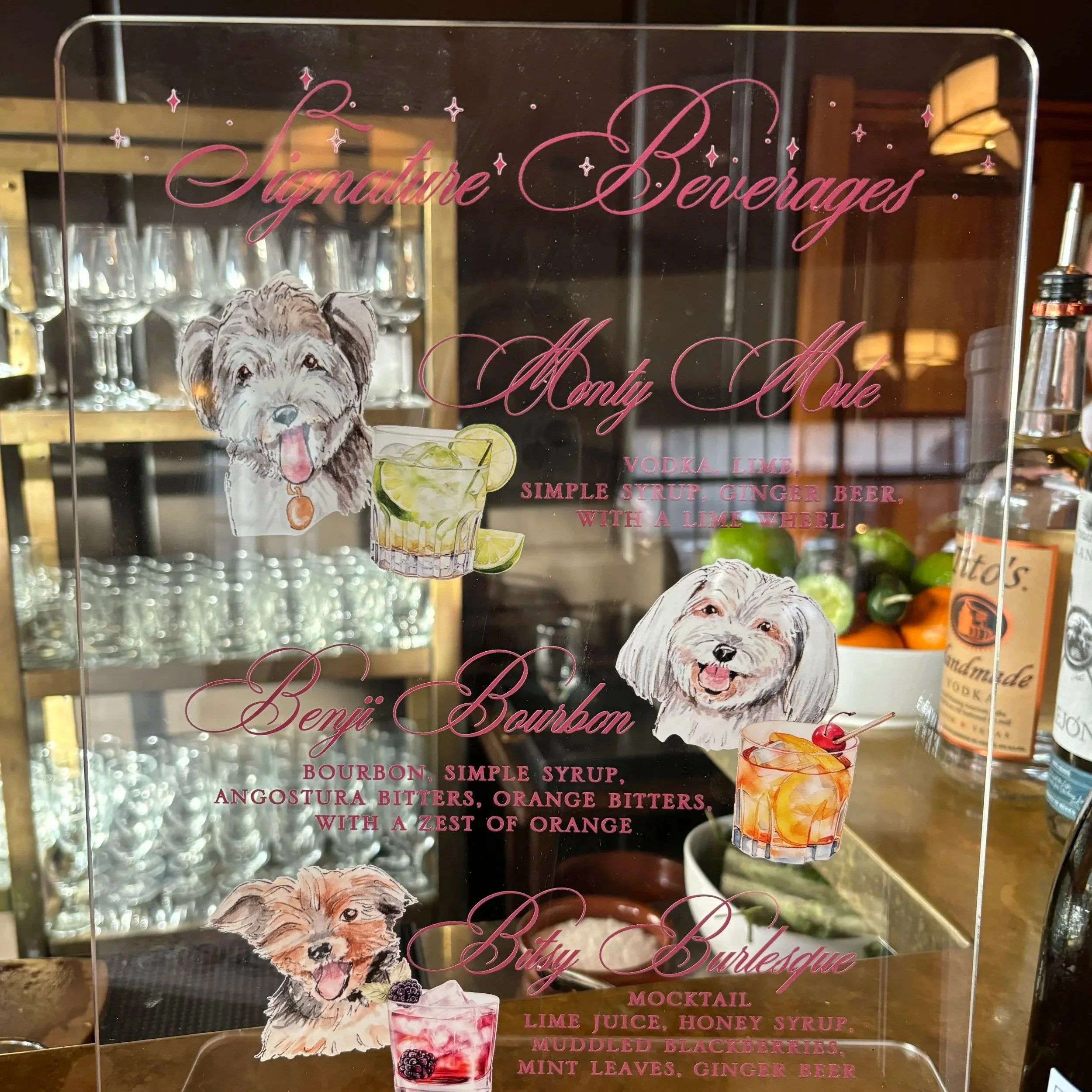 Bespoke acrylic wedding bar sign by Vogue Vignette featuring custom illustrated pet pawtraits alongside signature cocktail menus, hand-lettered in pink script.