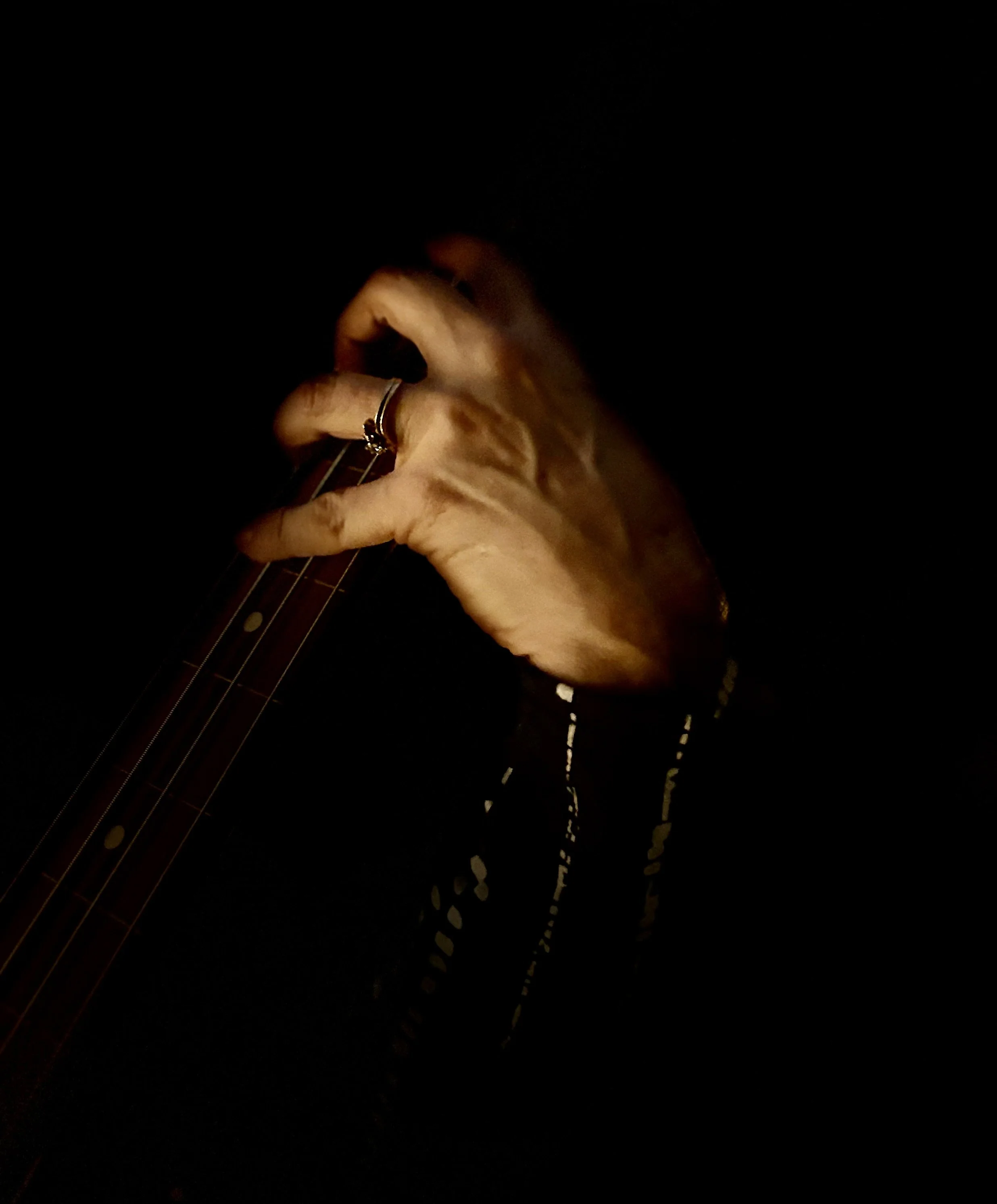 Her Hand Caressing a Fretless Bass