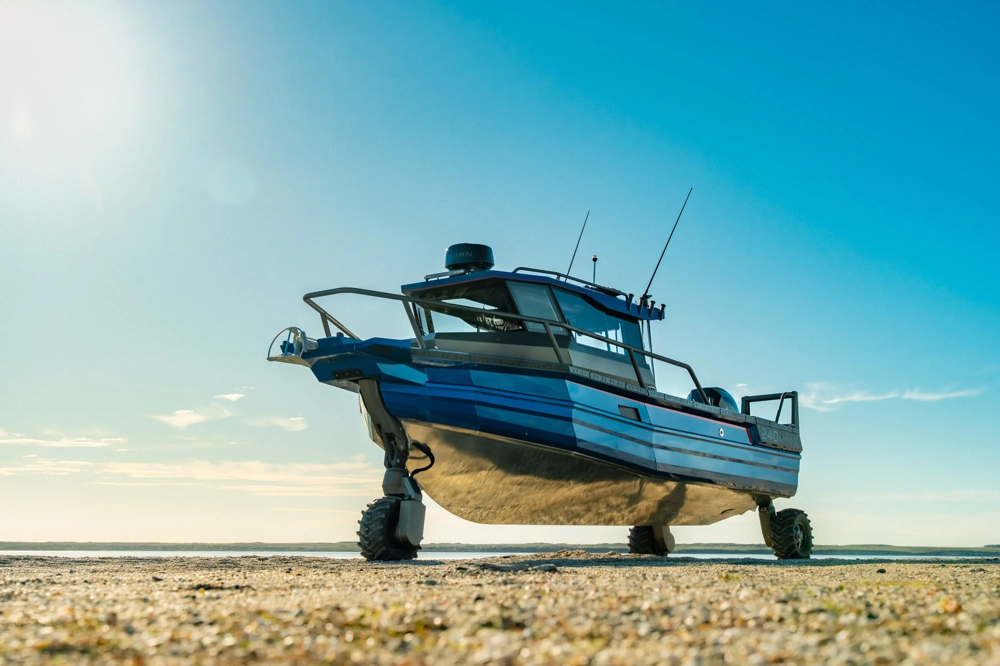240CC StabiX amphibious boat with the Tectrax wheel system - under a clear blue sky.