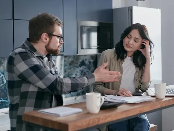couple arguing over bills in kitchen