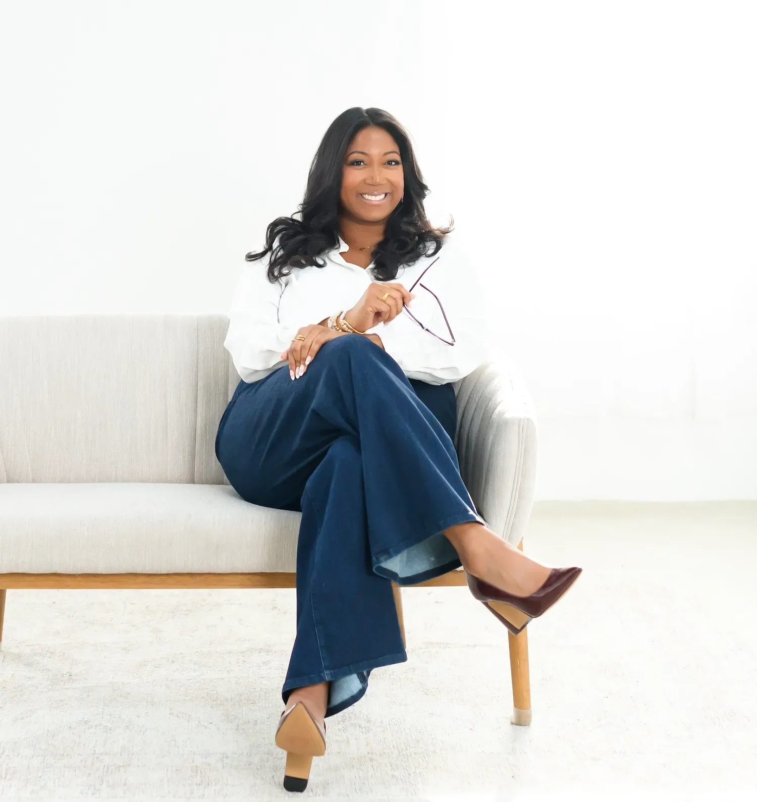 danielle graddick sitting on white sofa smiling