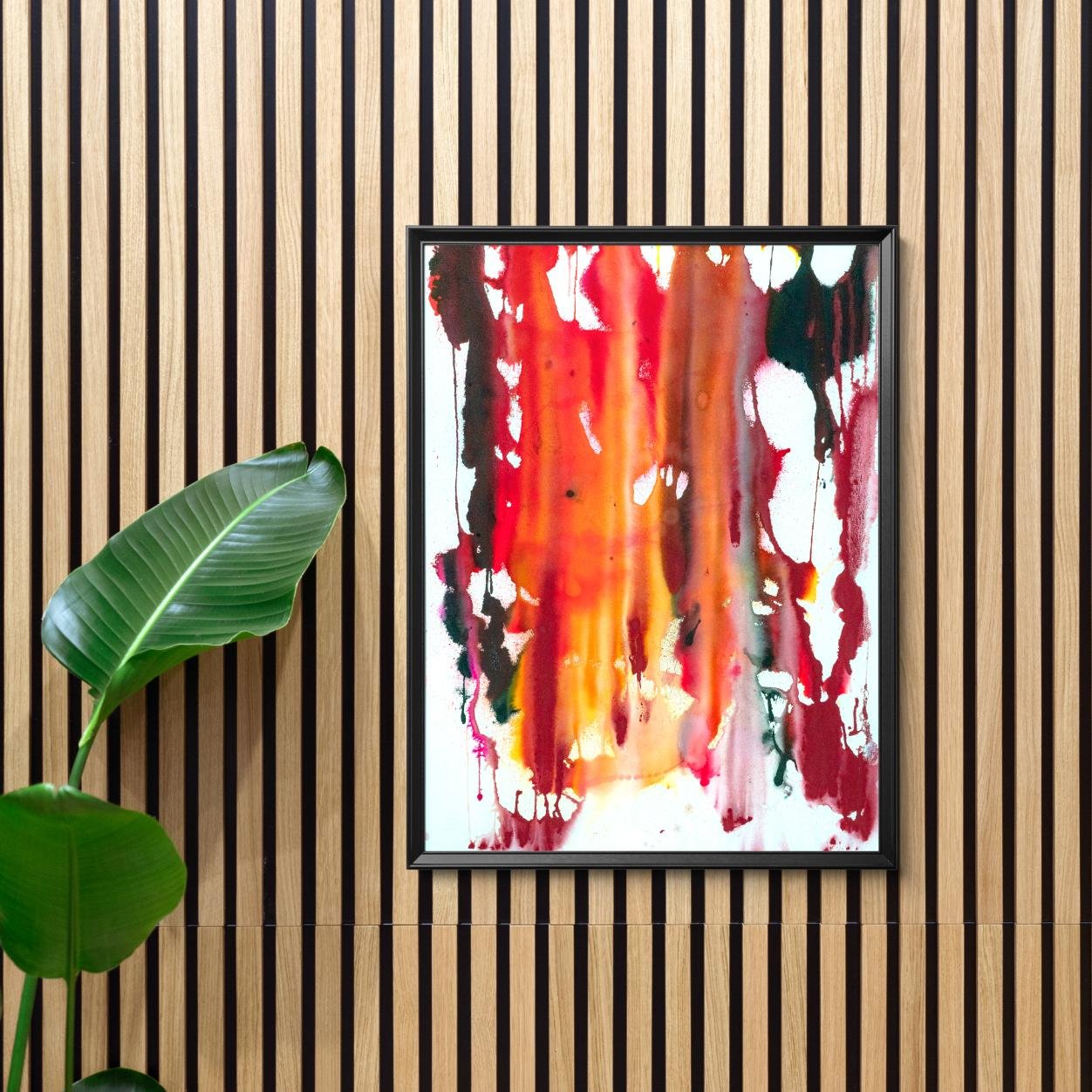 Summer Sweat” framed on a wood-paneled wall next to a green houseplant in a modern, minimalist interior.