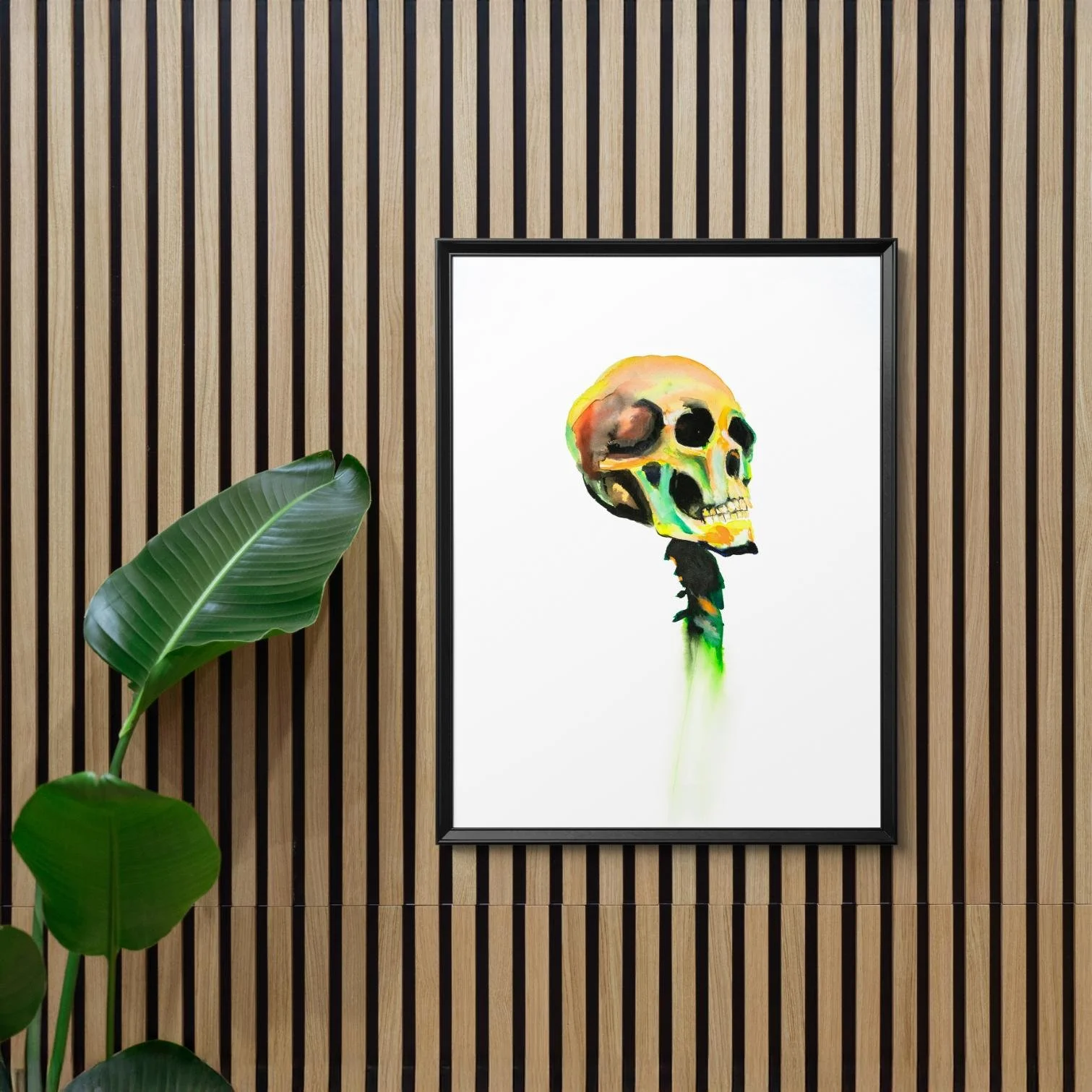 Multicolored skull framed in black, set on a striped wooden wall beside a lush green plant — modern, natural contrast