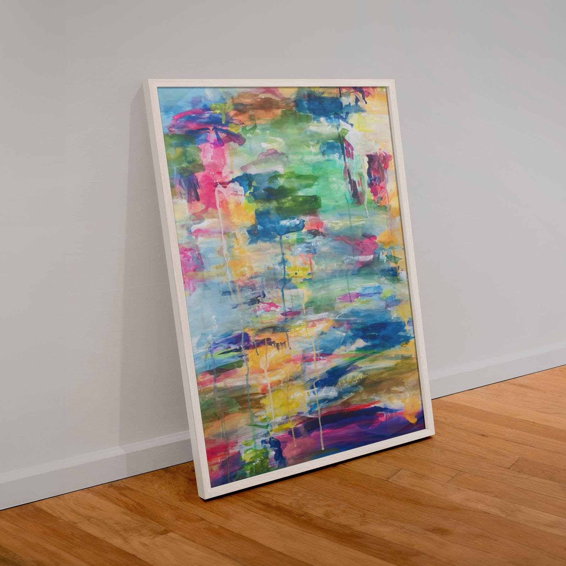 Framed painting of “Cascade” leaning against a gallery wall on a wooden floor, showcasing its bold colors and vertical composition in a casual, contemporary setting.