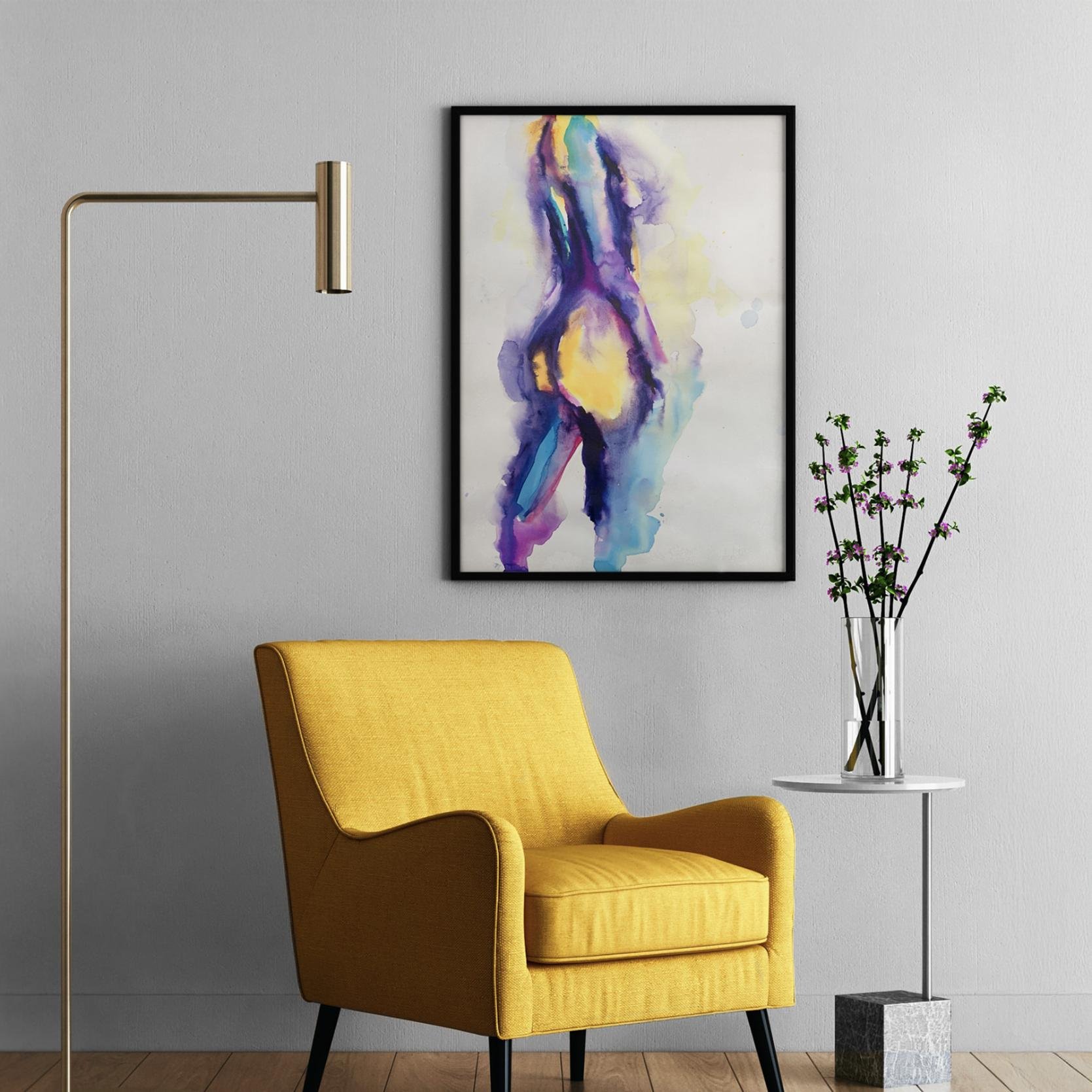 Framed artwork hangs above a golden-yellow chair and marble side table with floral stems, bringing bold color and elegance to a modern interior.