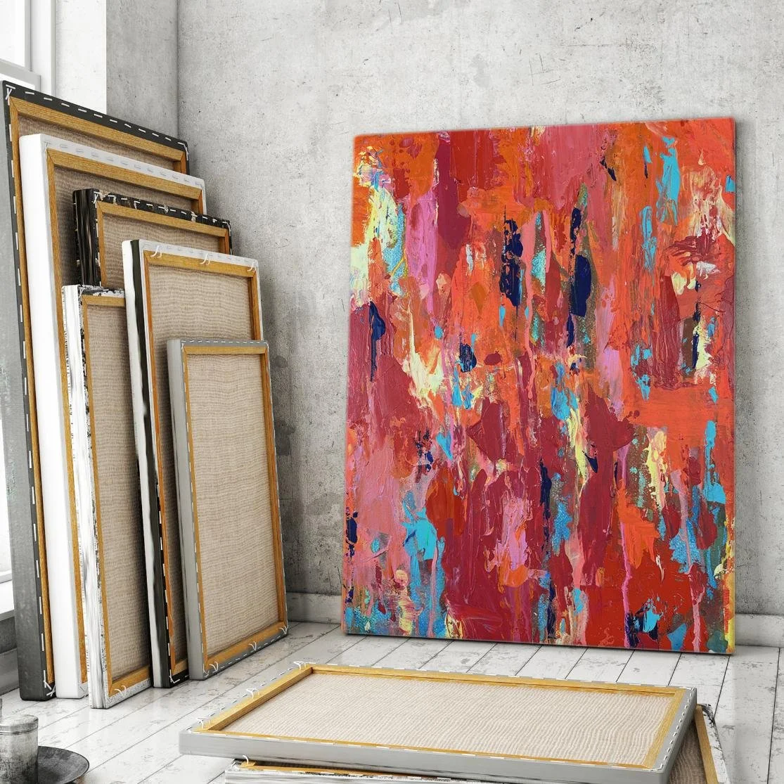 Ember featured in an artist’s studio setting, standing upright among other blank and completed canvases with a textured concrete wall backdrop.